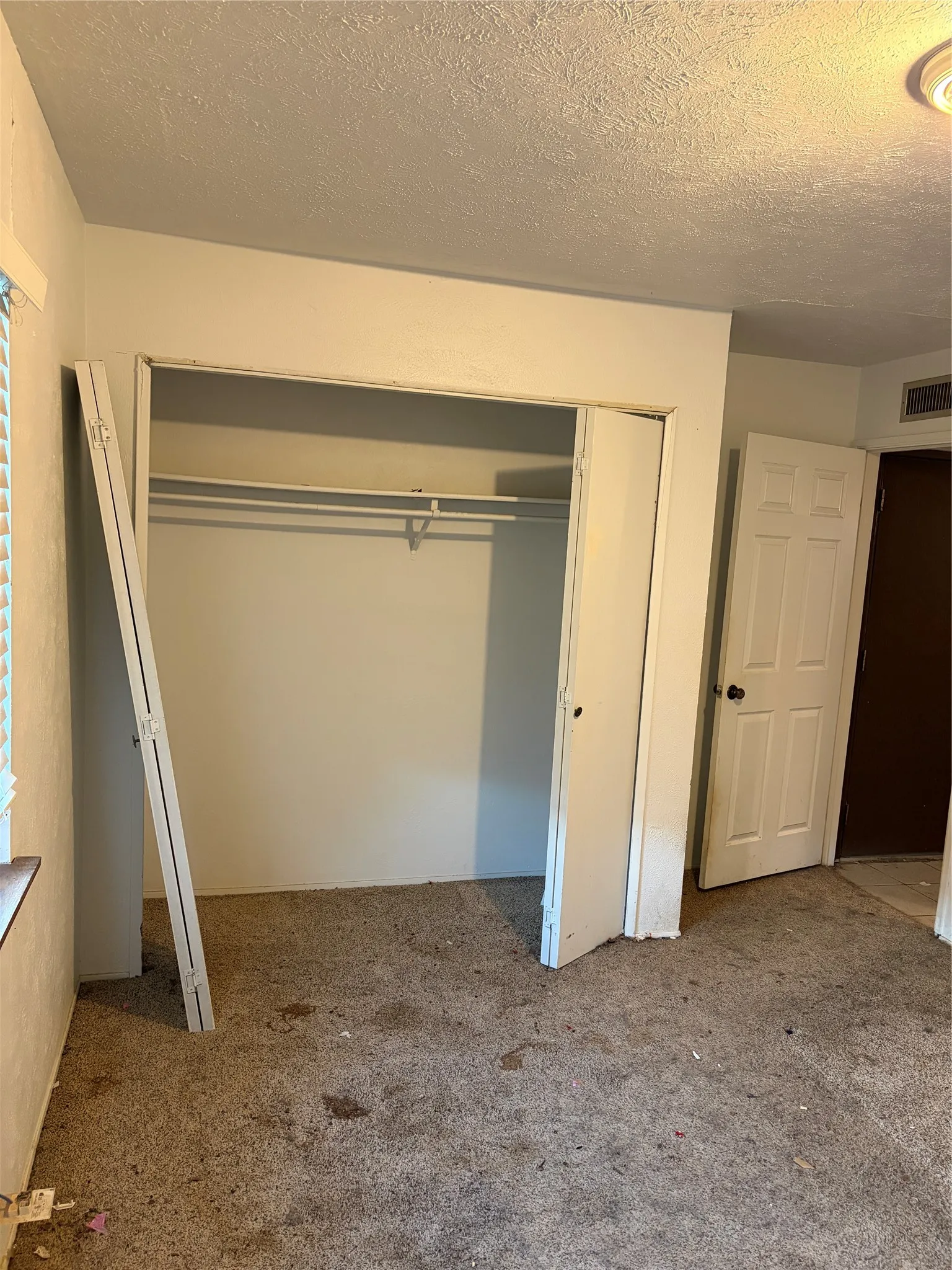 Built-in closet with integrated shelving, six-panel interior door, and neutral-toned wall finish