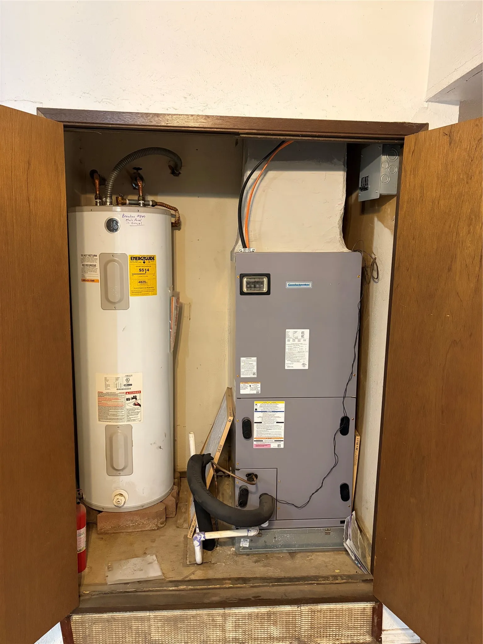 Utility closet featuring a vertical electric water heater and a dedicated air handler unit