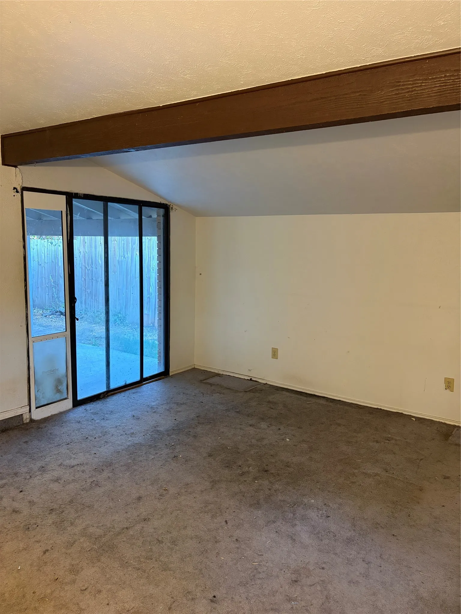Exposed wood beam ceiling featuring vaulted architecture and sliding glass door with external access