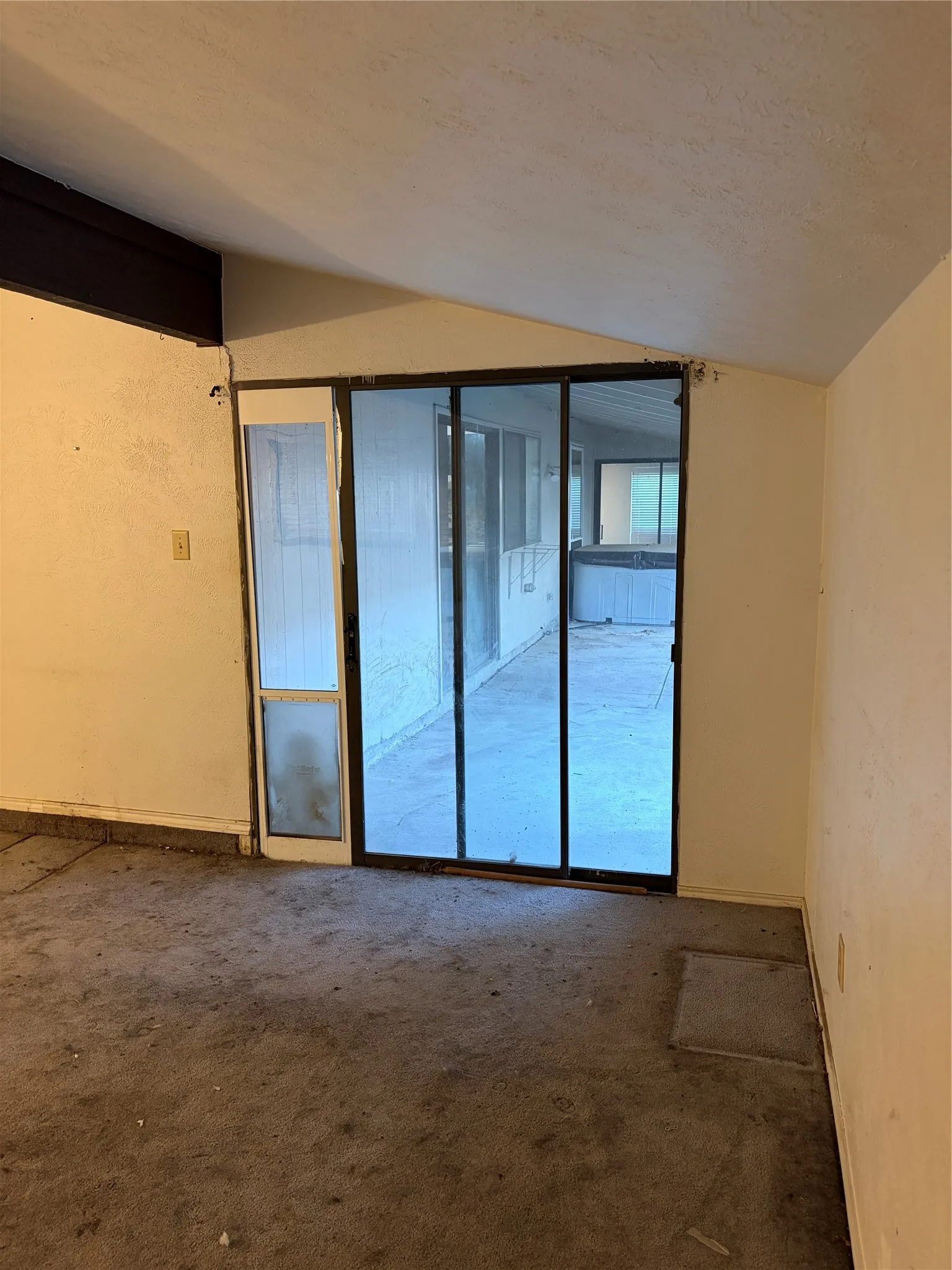 Sliding glass door with integrated side panel and sloped ceiling
