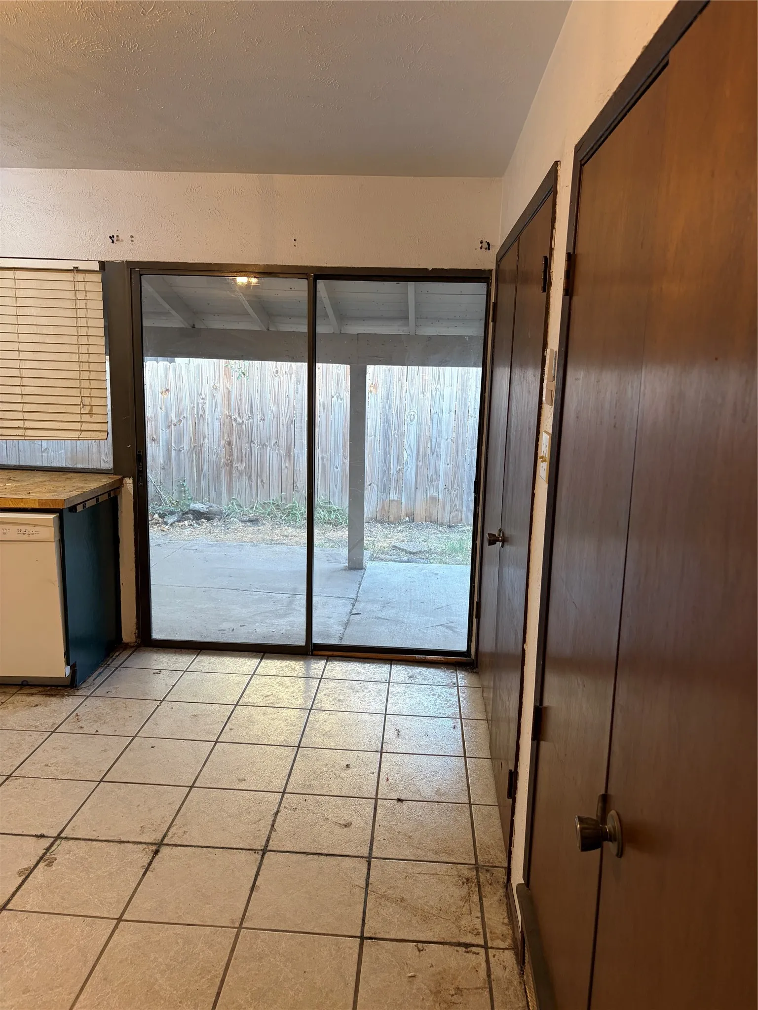 Ceramic tile flooring, sliding glass door with external patio access, wood-finish interior doors, and built-in cabinetry