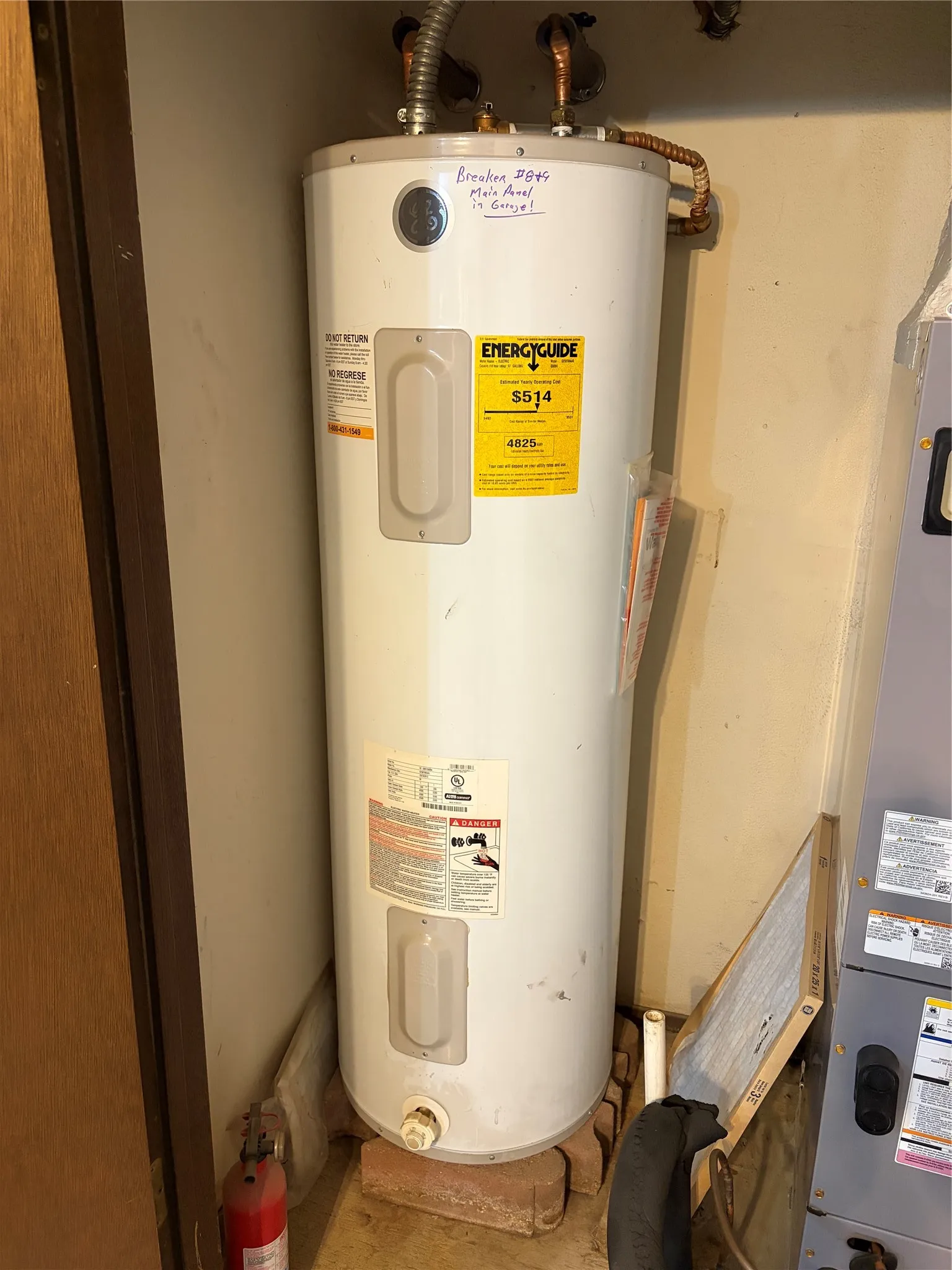 Electric water heater featuring copper plumbing connections and a dedicated base platform