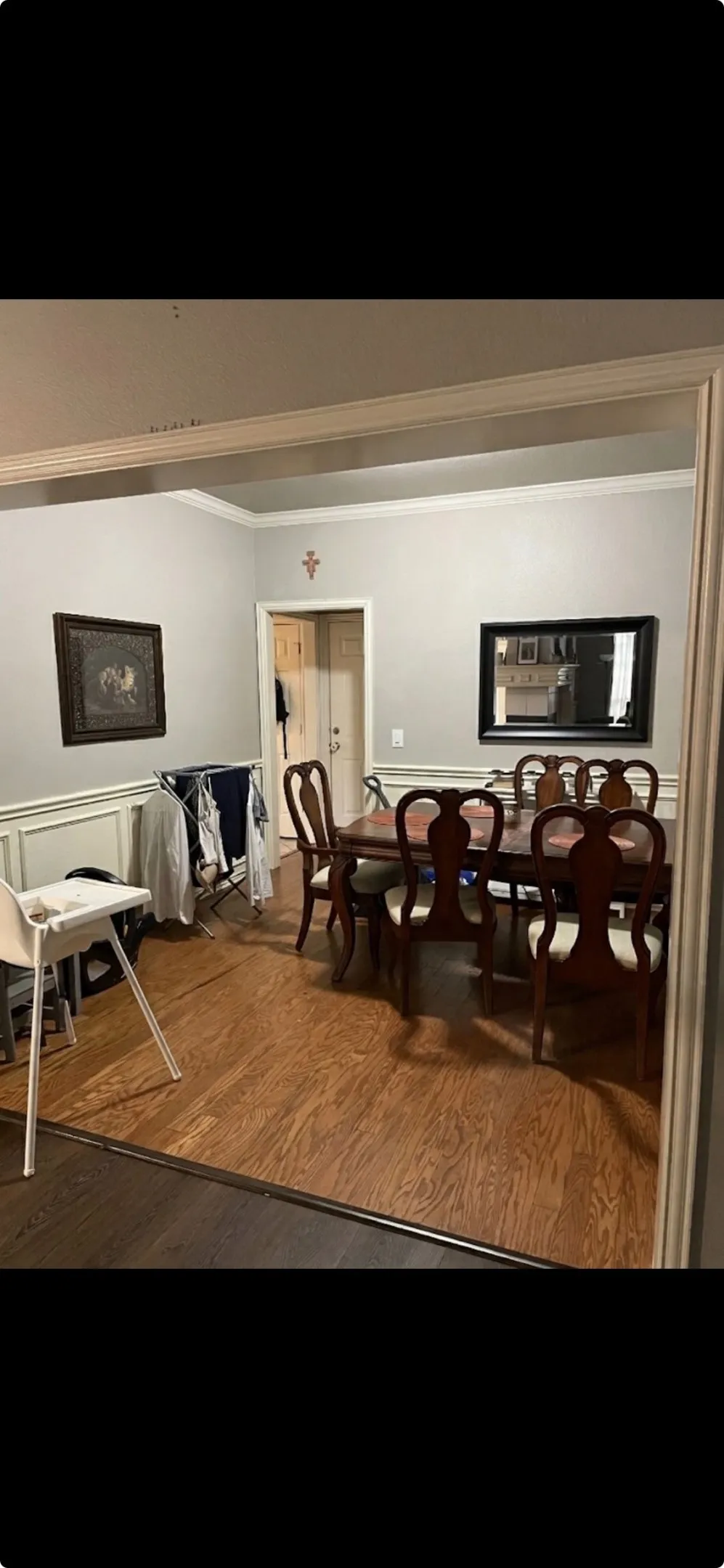 Room featuring wood-finish flooring, wainscoting, and crown molding