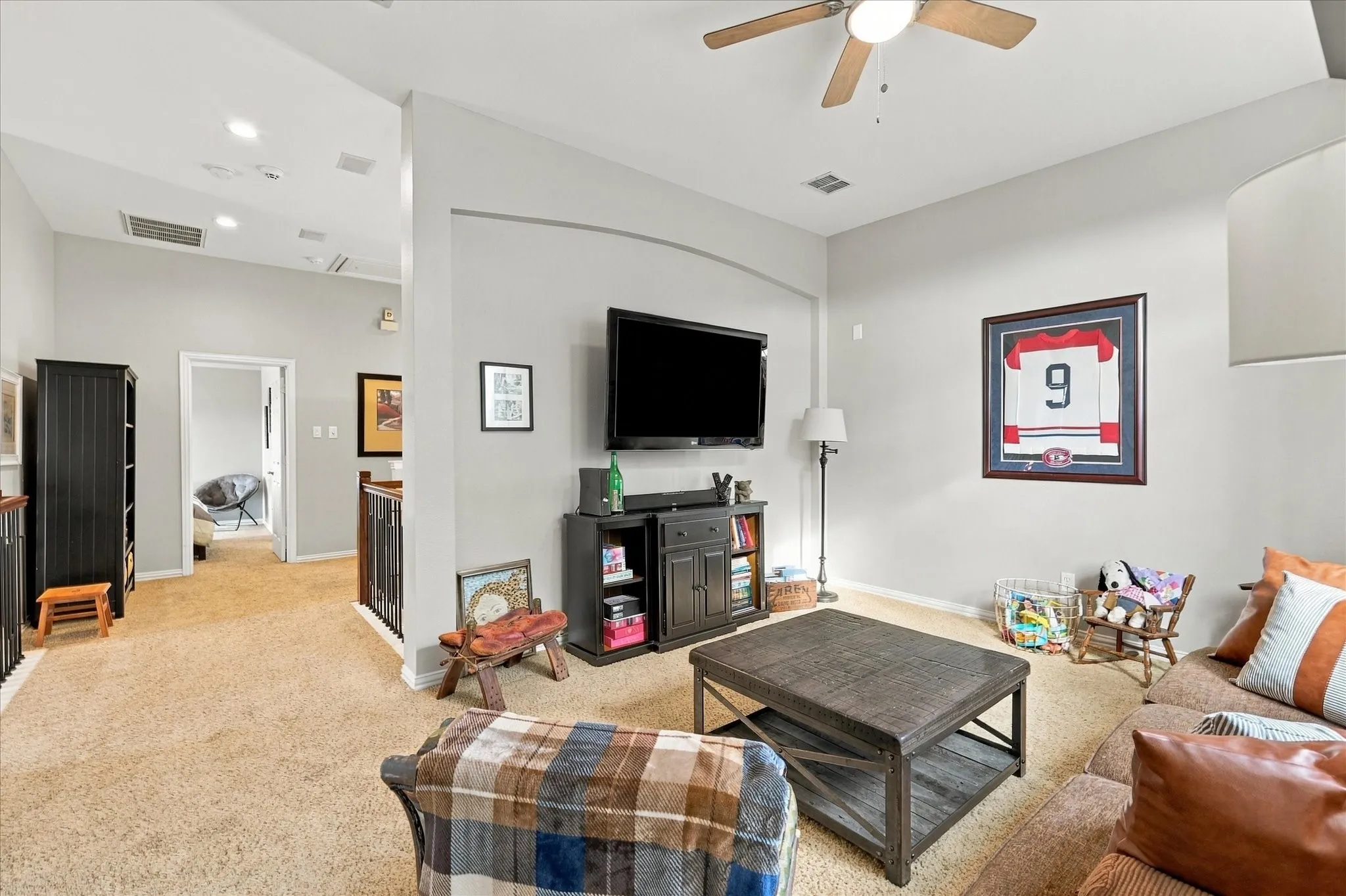 Vaulted ceilings, arched wall architectural detail, neutral wall paint, and ceiling fan fixture