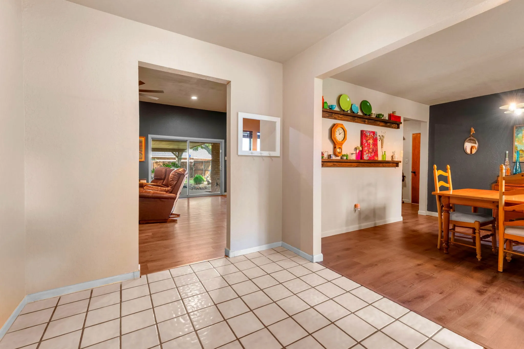 Sightlines run from the entry through the living room to the backyard, with new luxury vinyl plank flooring flowing throughout the home.