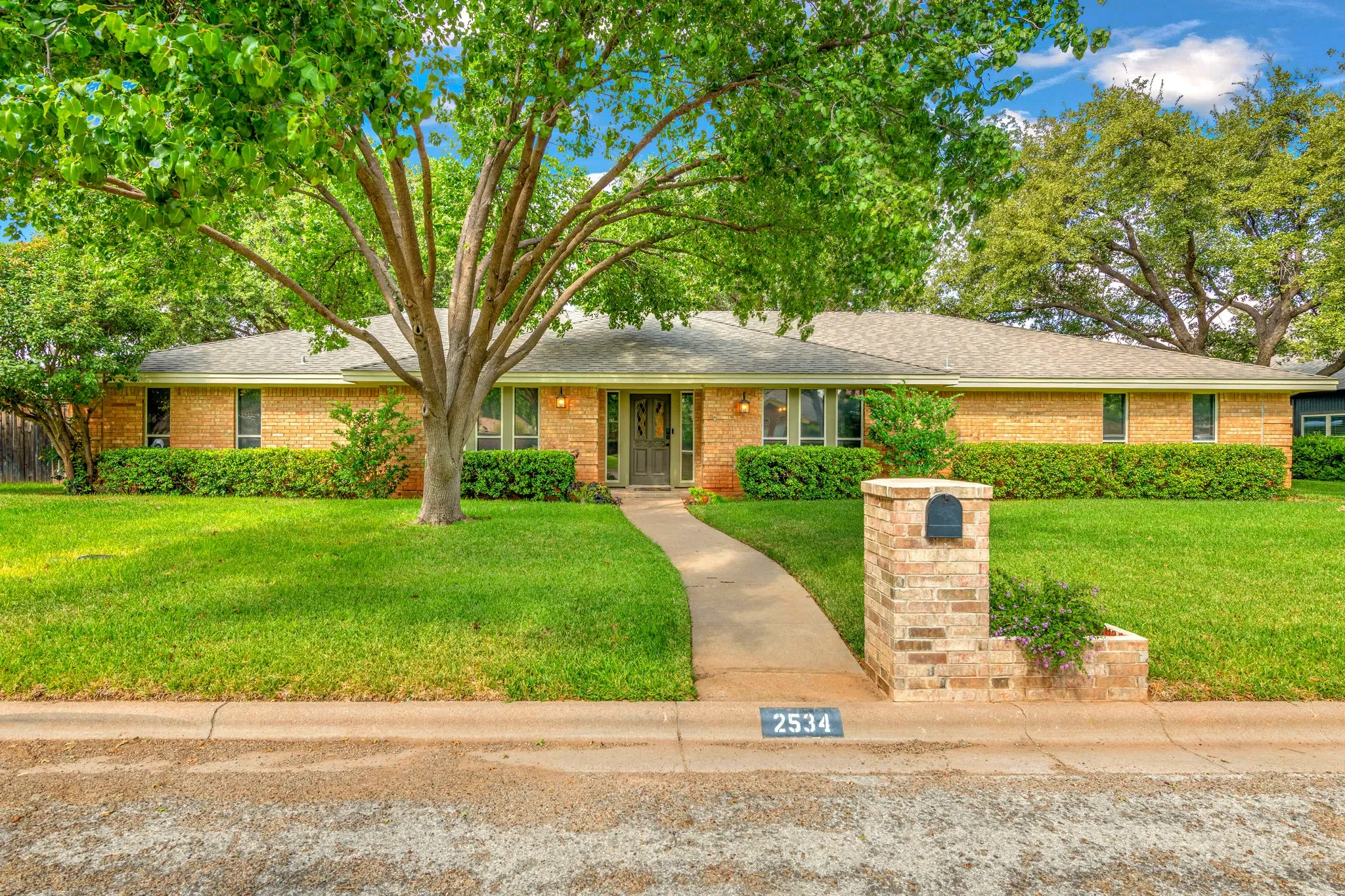 Welcome home to 2534 Meadow Lake Dr, where a stately shade tree, neutral color exterior paint, and a manicured lawn make a warm first impression.