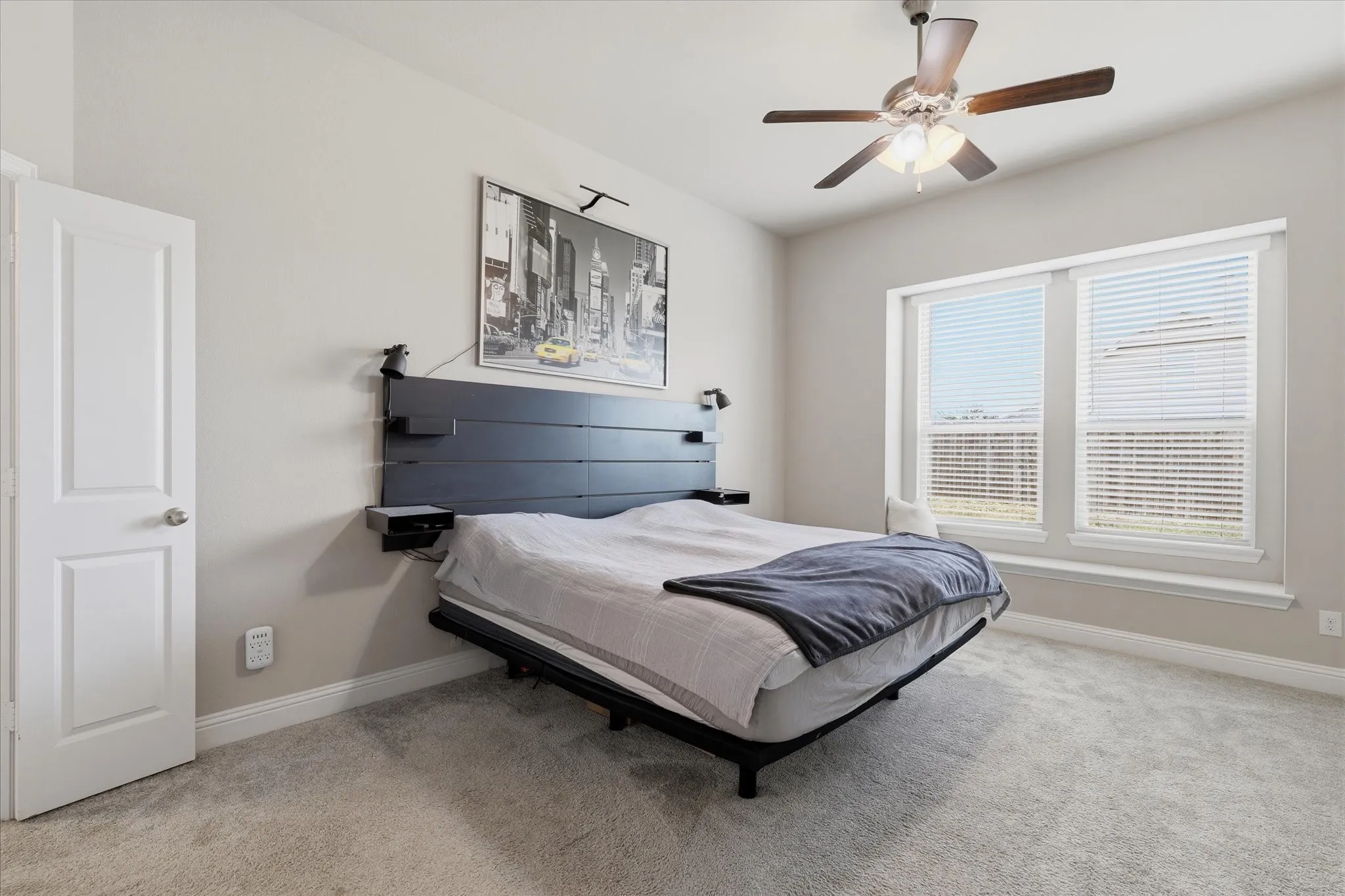 Spacious primary bedroom, window coverings.