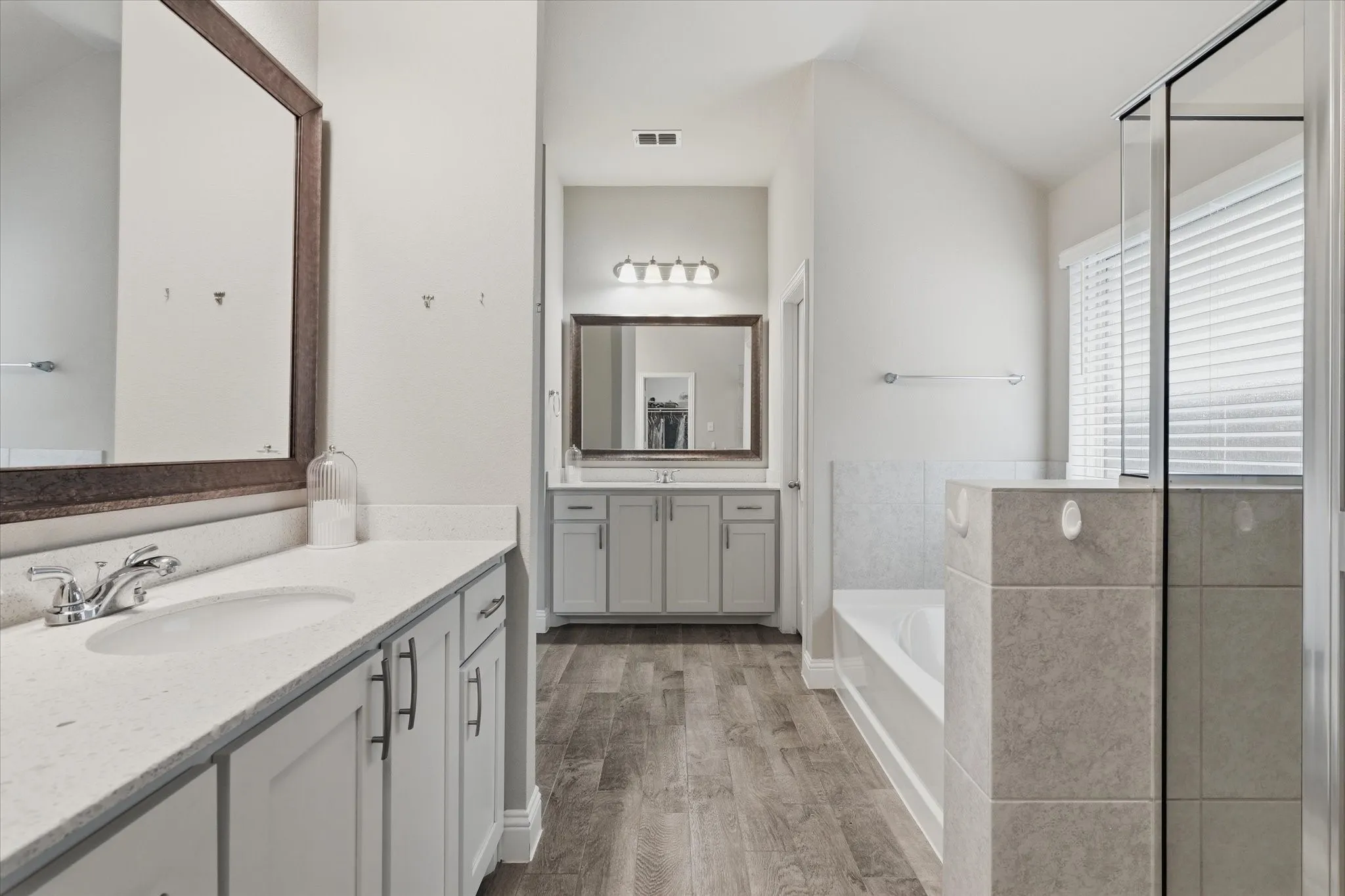 Clean lines, oversized vanity mirrors, storage and ceramic title flooring make this primary bath one you will not want to miss out on!