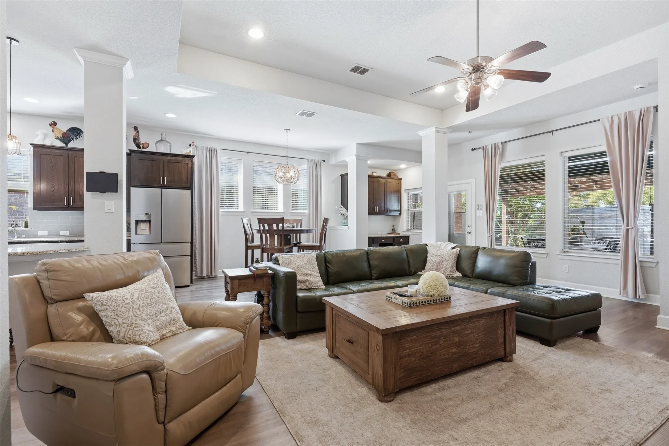 Open concept interior featuring a tray ceiling, recessed lighting, wood-finish flooring, and a ceiling fan with integrated light fixture