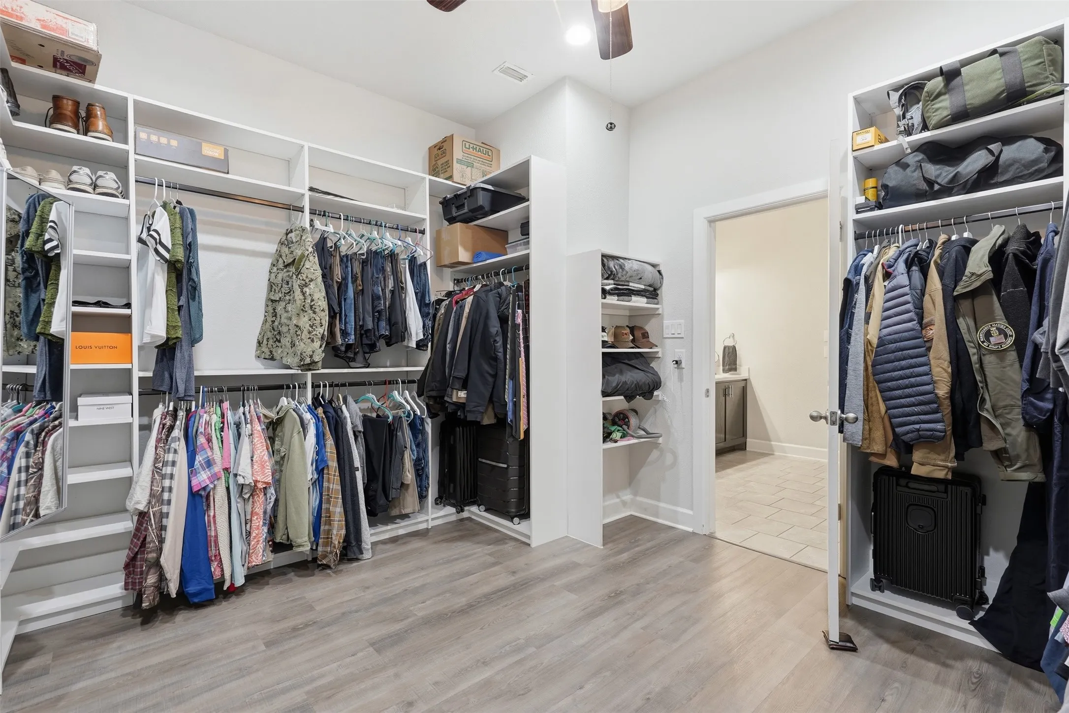 HUGE custom Walk-in closet featuring extensive built-in white shelving, multiple hanging rods, pull out belt and tie racks and mirror
