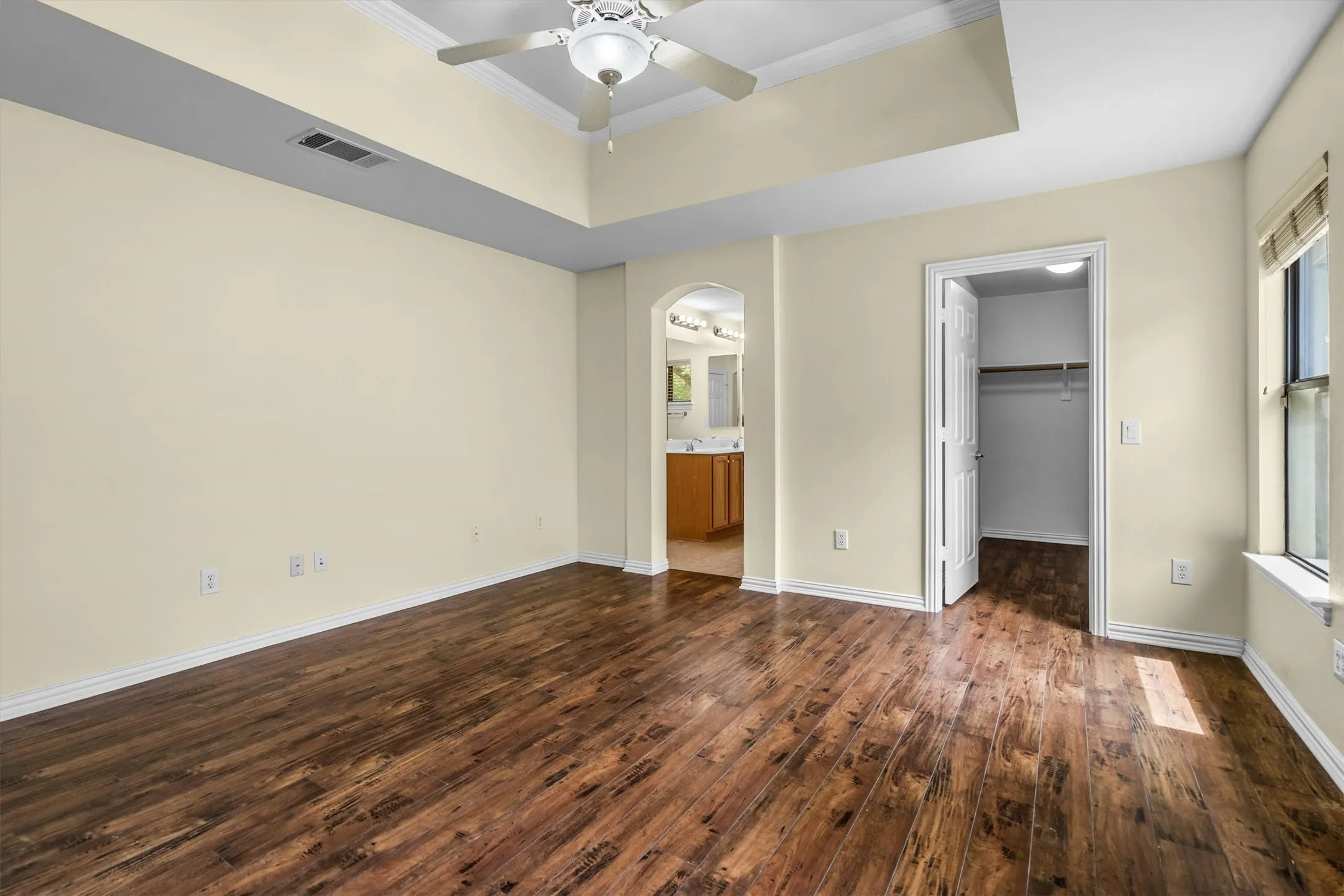 Primary bedroom with views of the walk in closet and double vanity bathroom