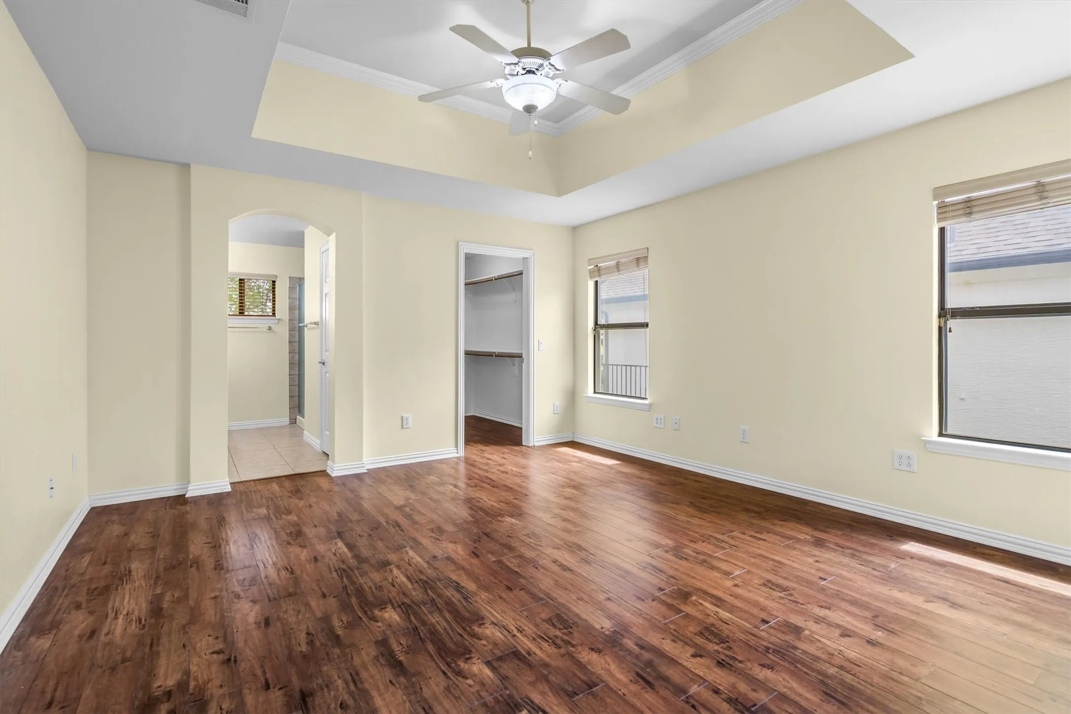 The primary bedroom with engineered wood floring and coffered ceiling