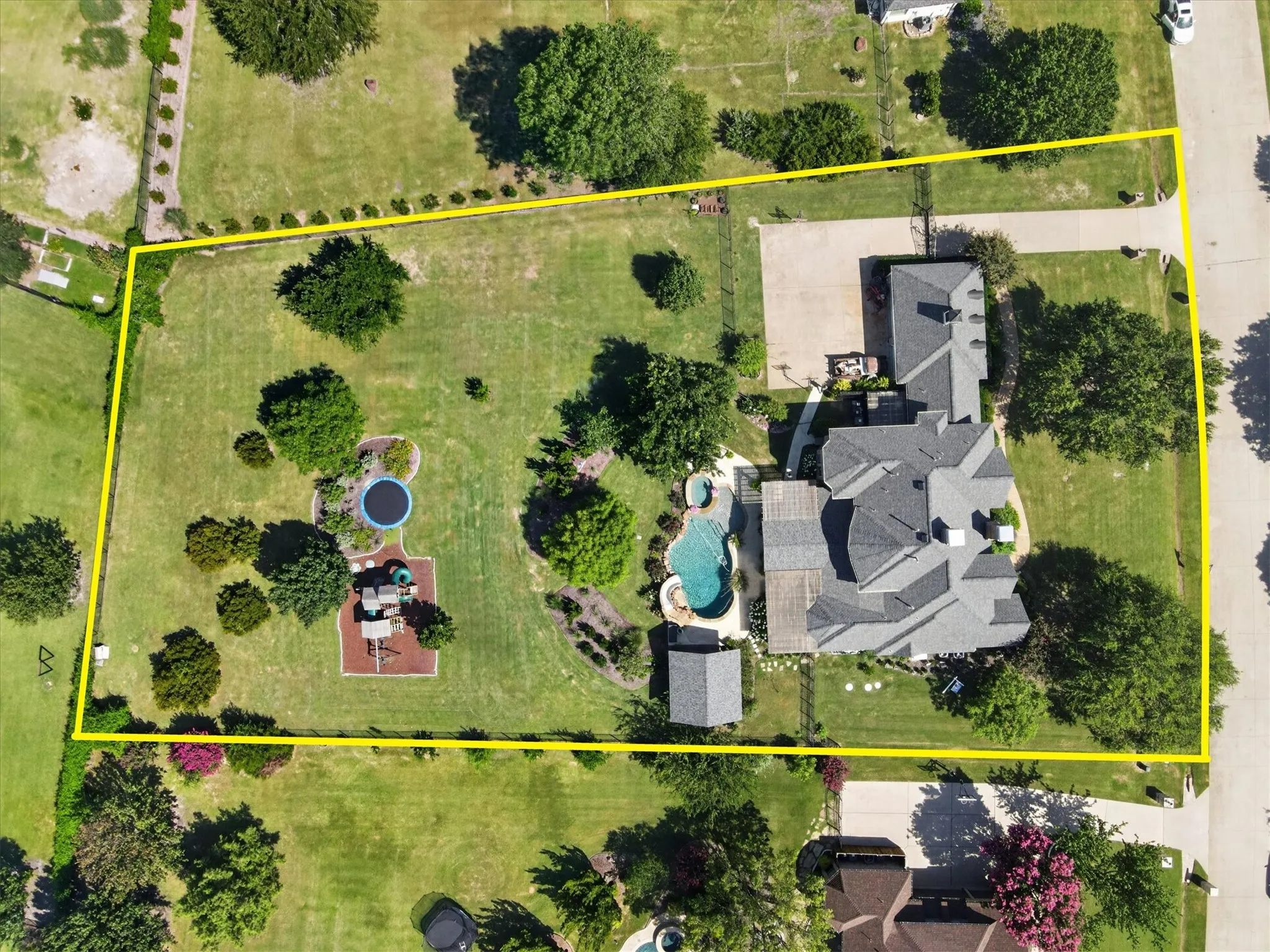 Expansive grounds featuring a swimming pool, integrated spa, detached structure, and mature landscaping