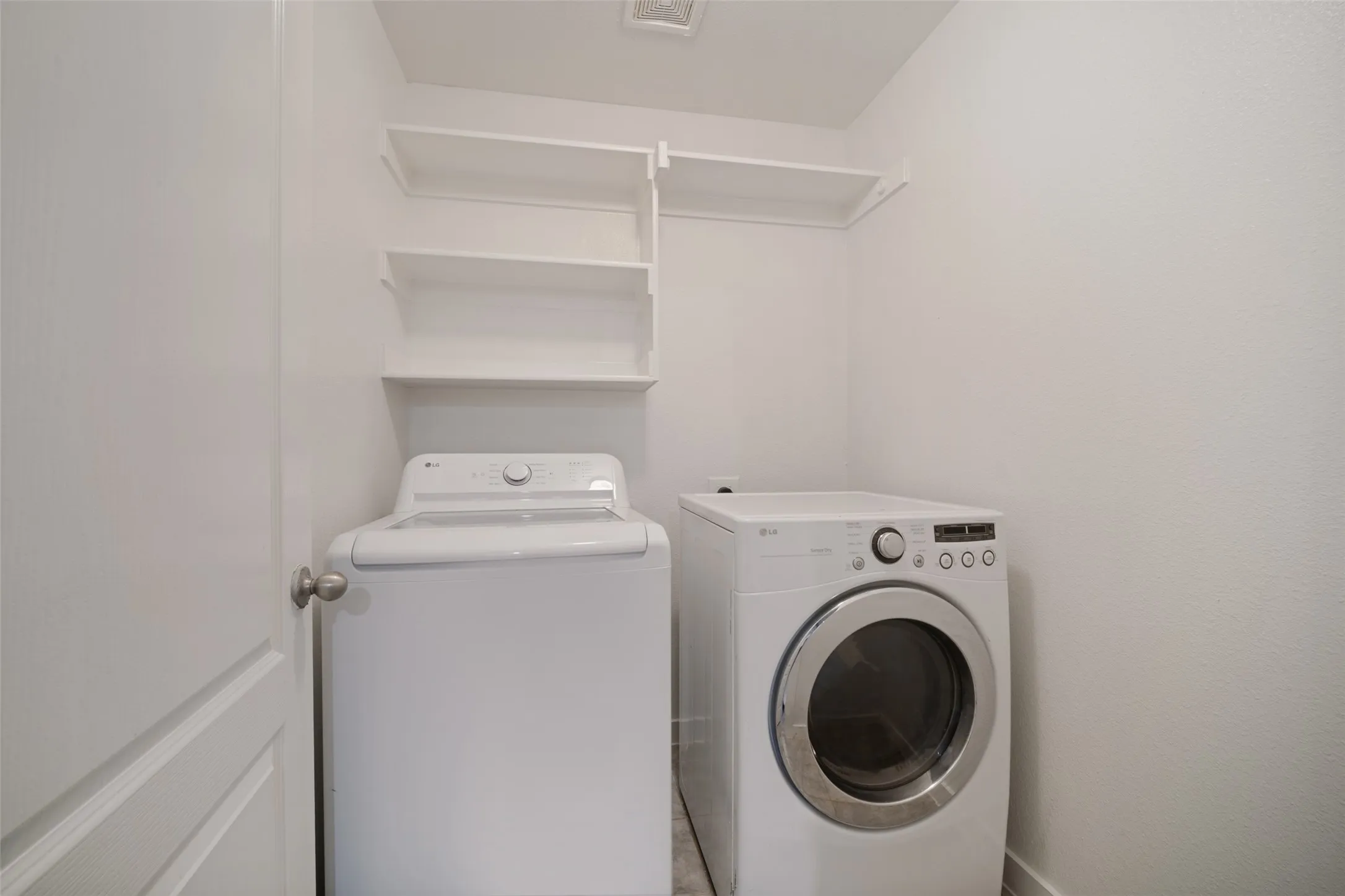 Laundry area featuring white built-in wall shelving