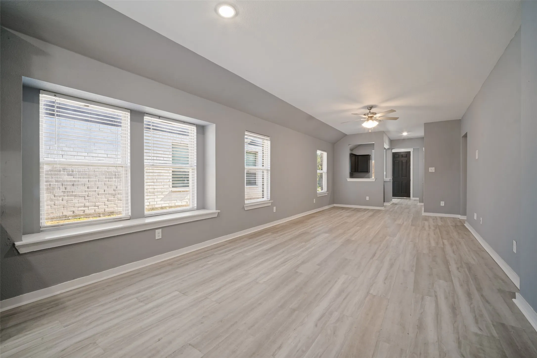 Open-concept room featuring wood-finish flooring, a recessed window seat, recessed lighting, and a ceiling fan