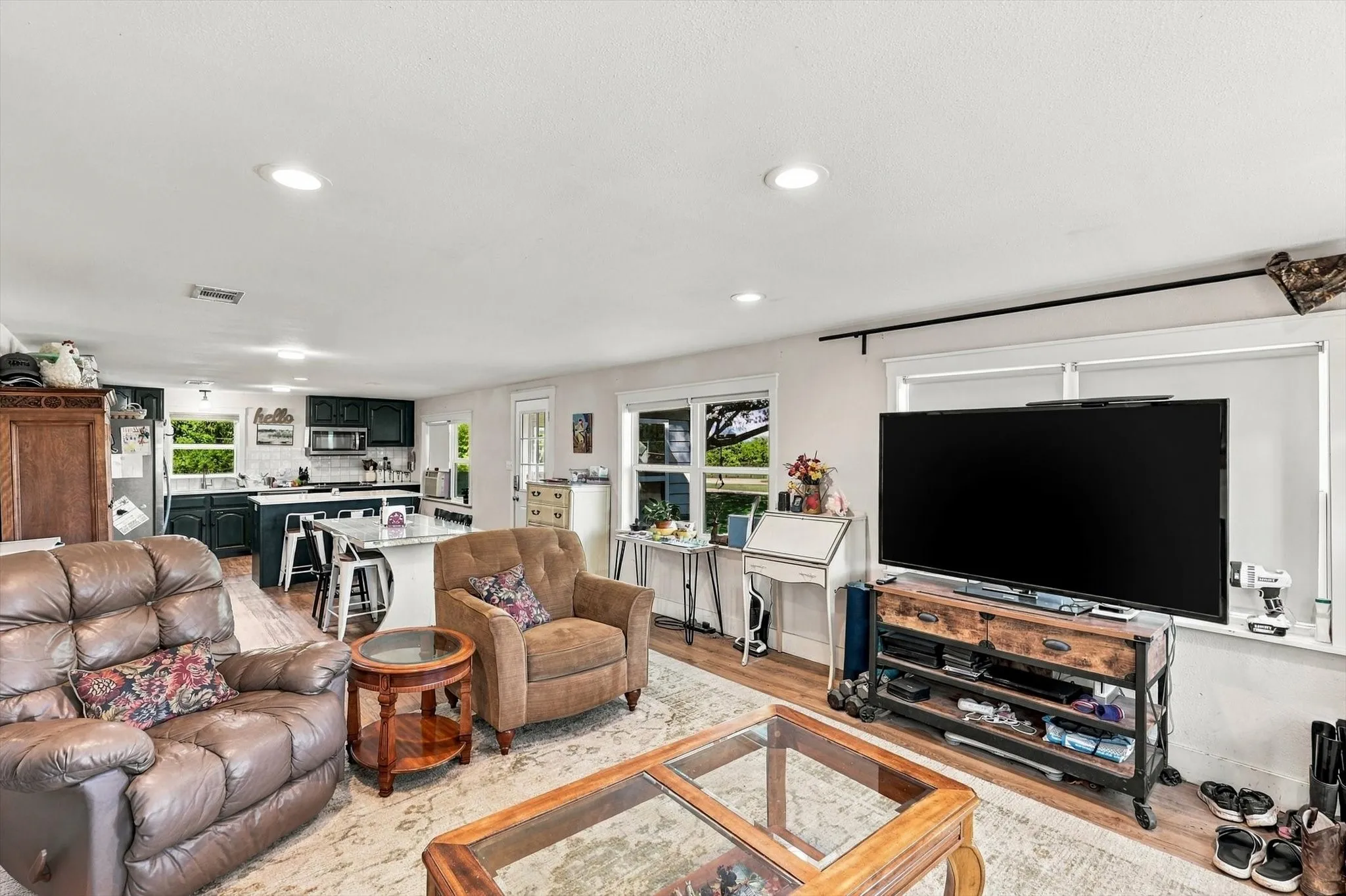Open-concept interior featuring wood-finish flooring, recessed lighting, and a kitchen island with stone countertop