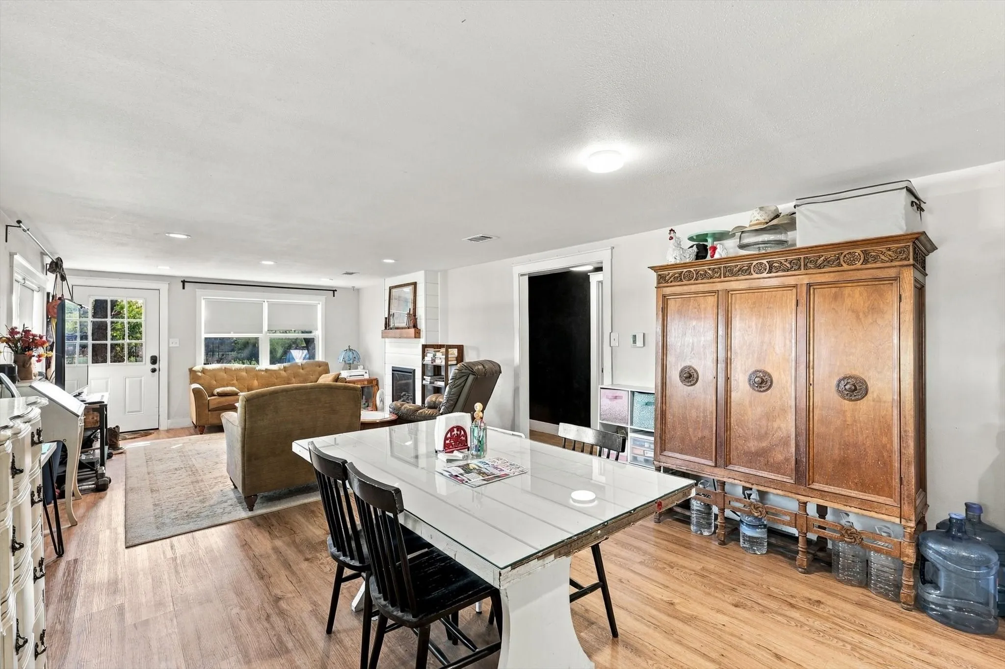 Open-concept interior featuring wood-finish flooring, recessed lighting, and a fireplace with a wood mantel