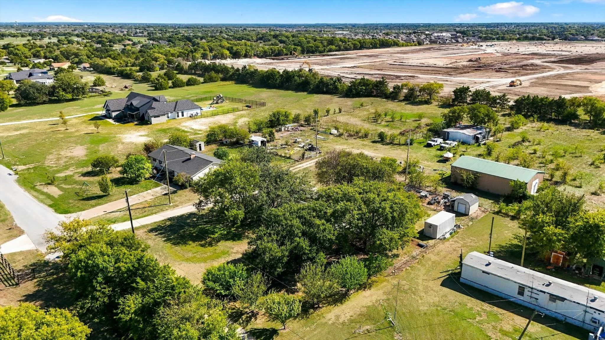 Expansive lot featuring mature trees, a detached multi-purpose storage structure, and open space