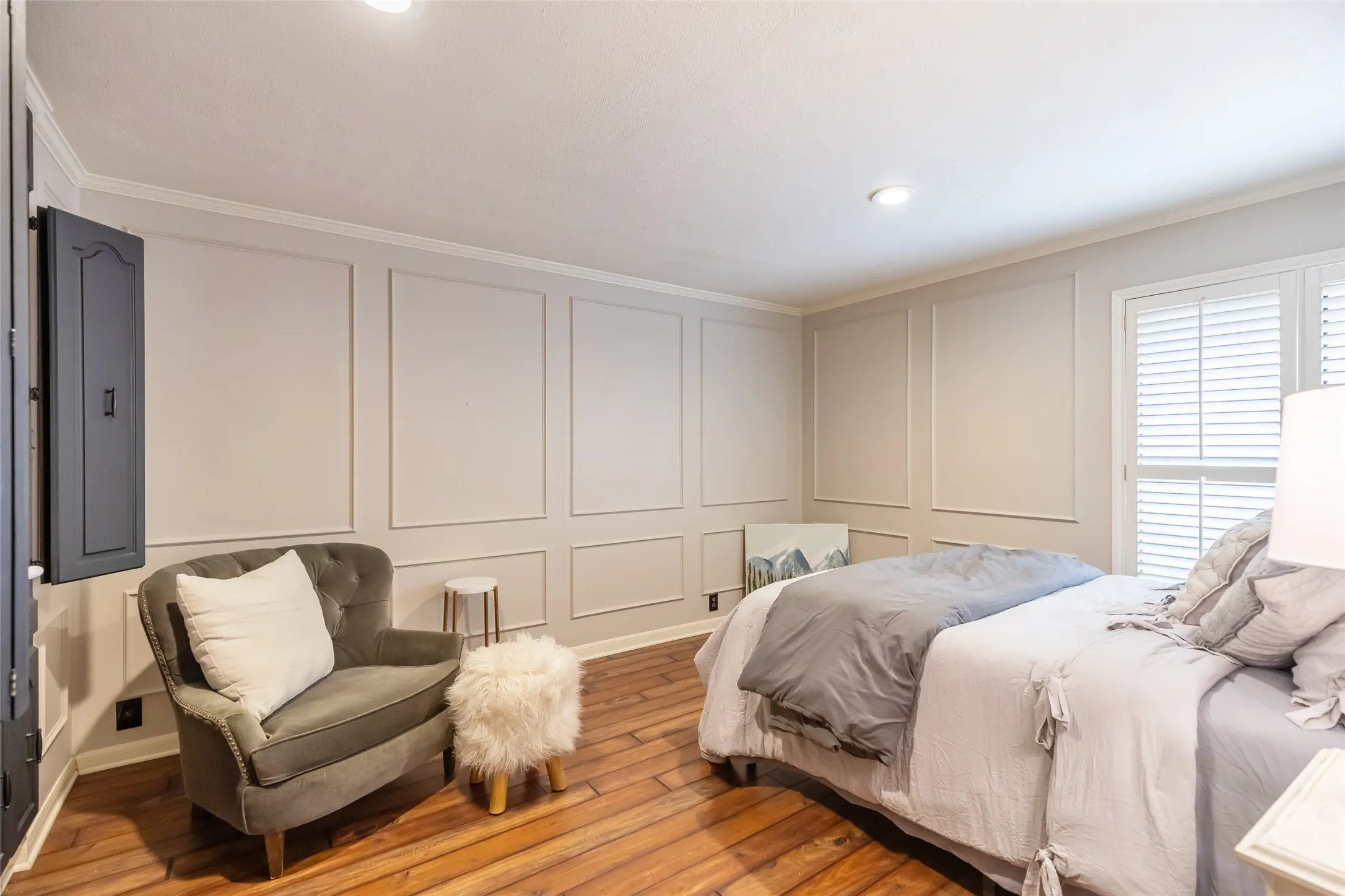 Wood-finish flooring, wainscoting-style wall molding, and interior shutters