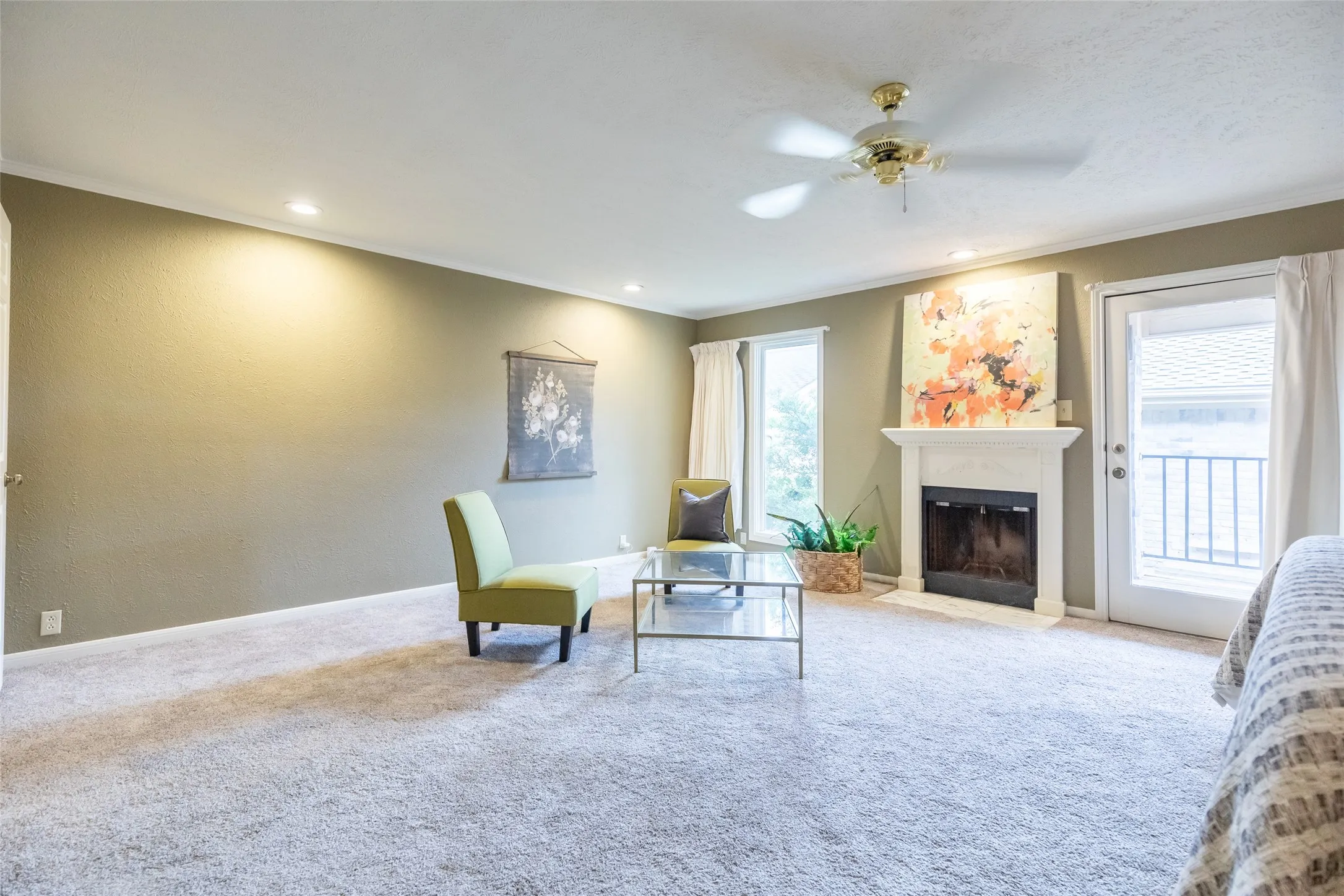Fireplace with a classic white mantel, ceiling fan, recessed lighting, carpeted flooring, and a glass-paneled exterior door