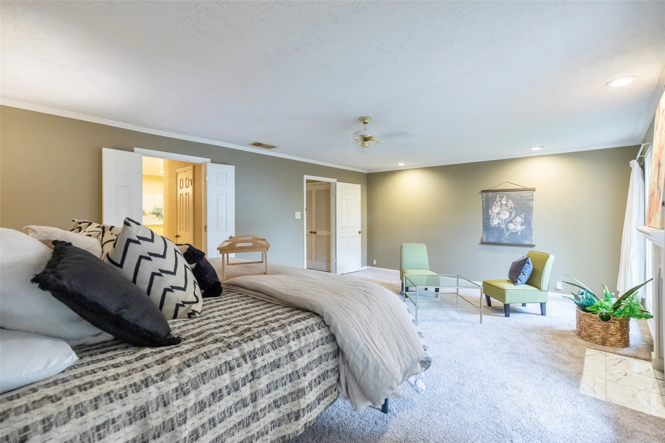 Spacious room featuring neutral wall paint, carpeting, ceiling fan, and white paneled doors