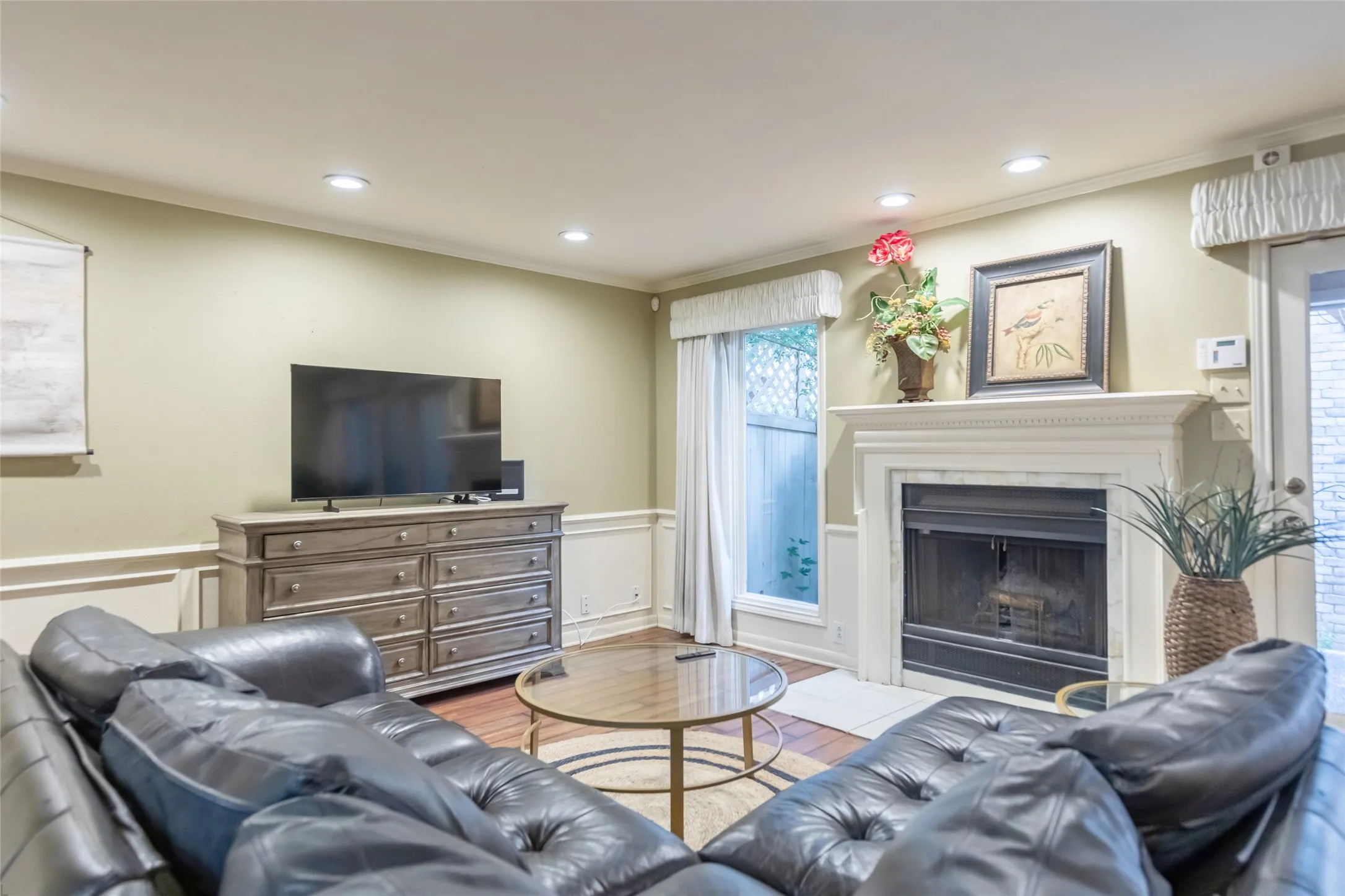 Living area featuring recessed lighting, chair rail molding, and a fireplace with a decorative mantel and stone surround
