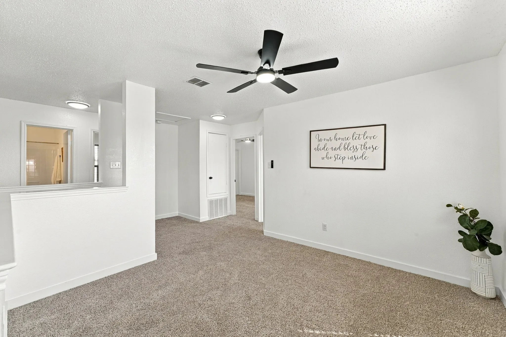 Neutral interior space featuring carpeted flooring, a ceiling fan with integrated lighting, and recessed overhead illumination