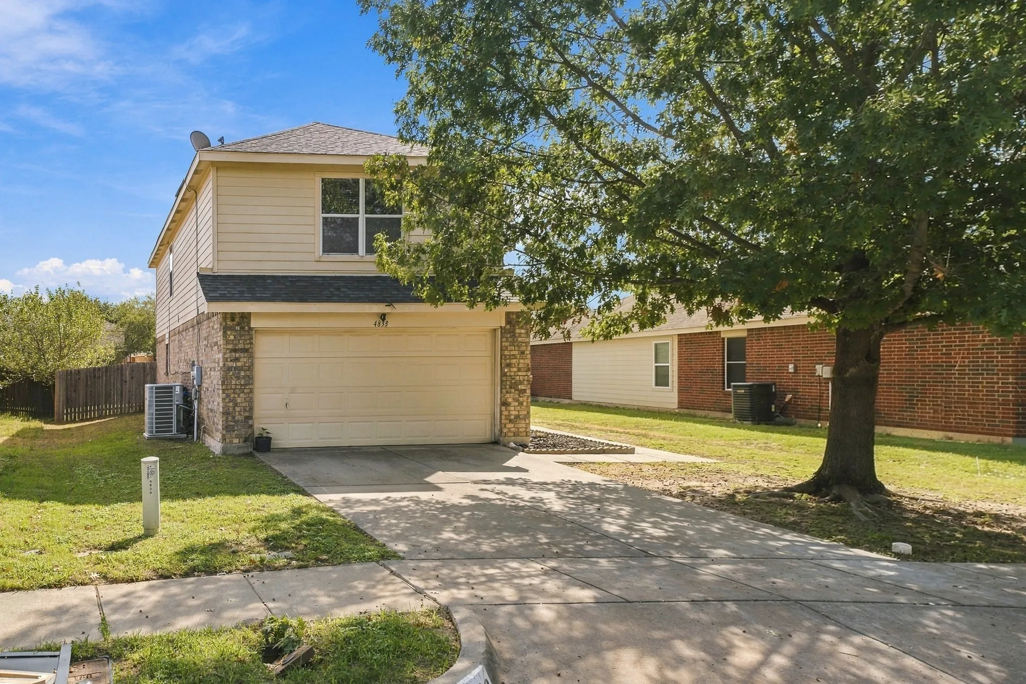 Two-story residence featuring a combination stone and siding exterior, an attached two-car garage, and a concrete driveway