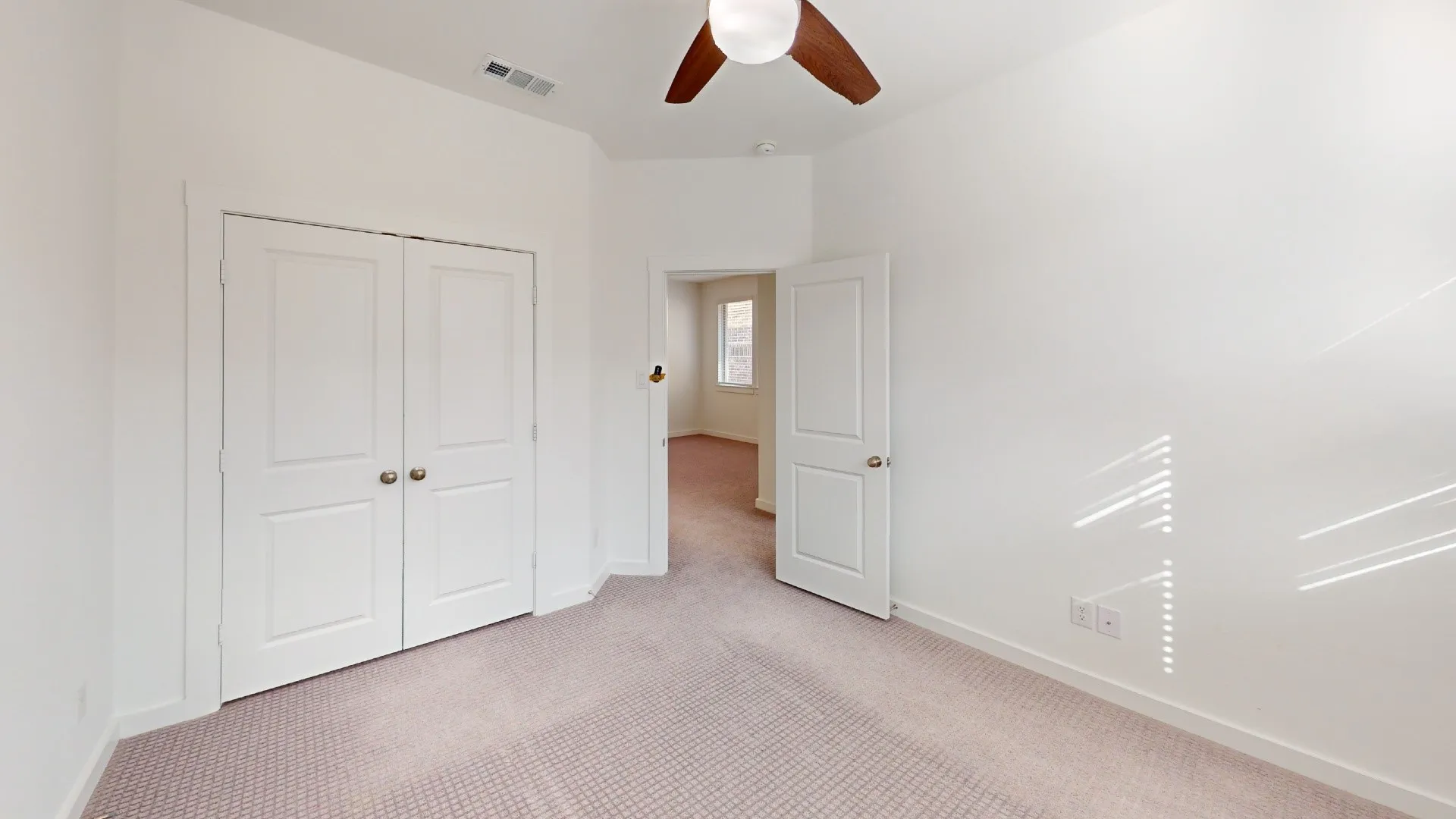 Interior room featuring neutral carpeting, double-door closet, ceiling fan, and multi-panel interior doors