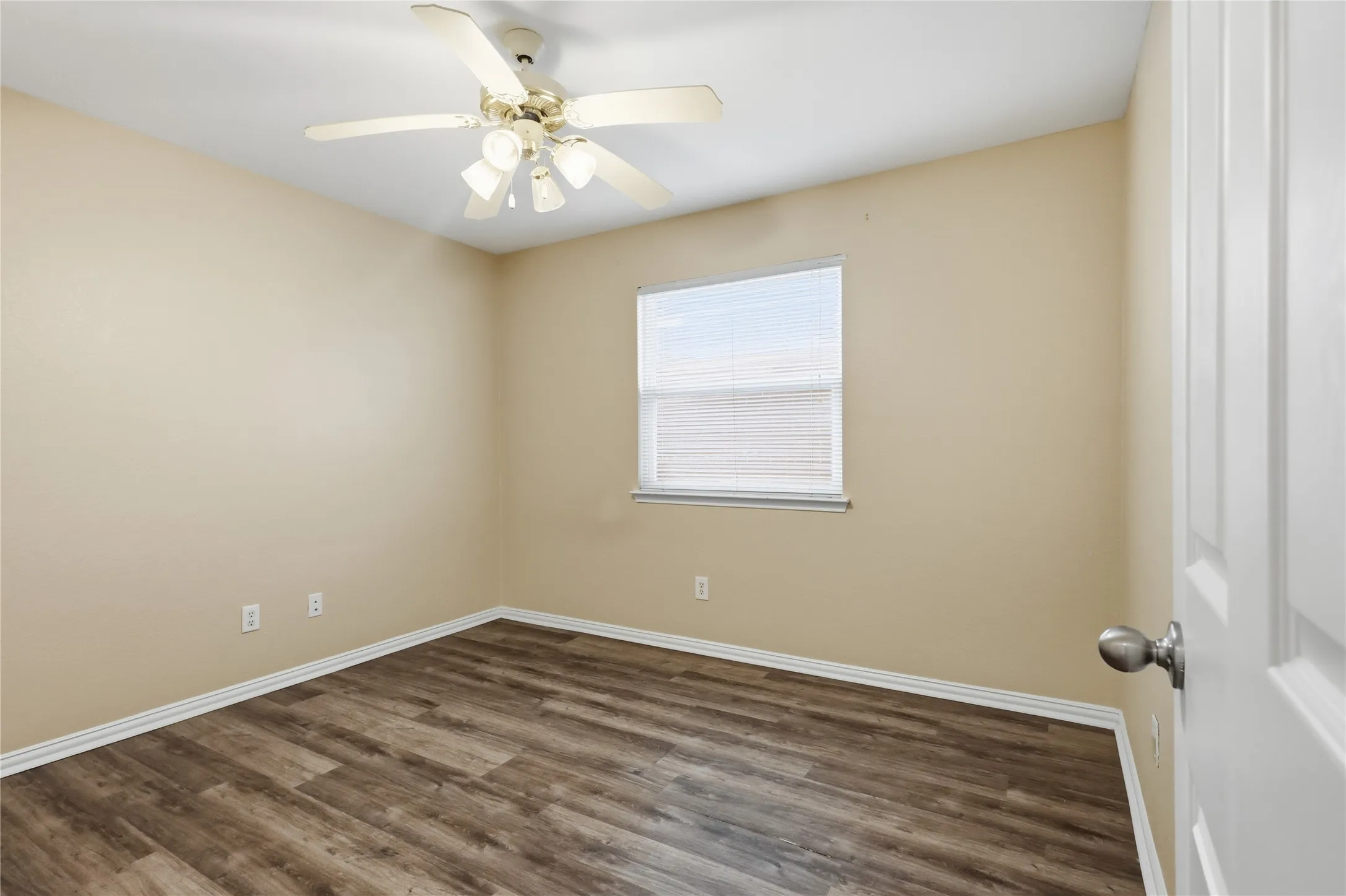 Room featuring wood-finish flooring, a neutral wall palette, a single-pane window with integrated blinds, and a multi-light ceiling fan