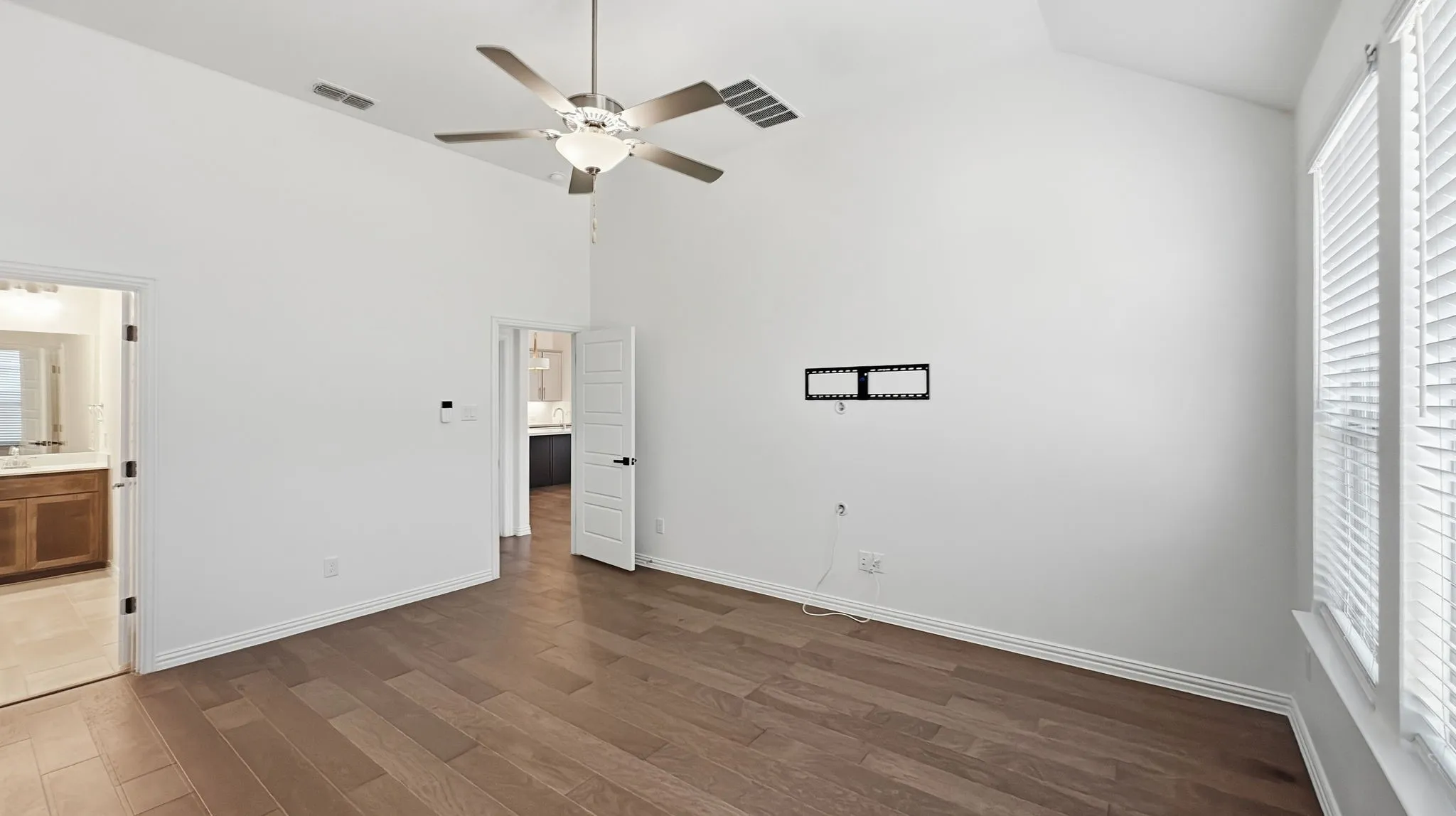 Vaulted ceilings, wood-finish flooring, and a ceiling fan with integrated lighting