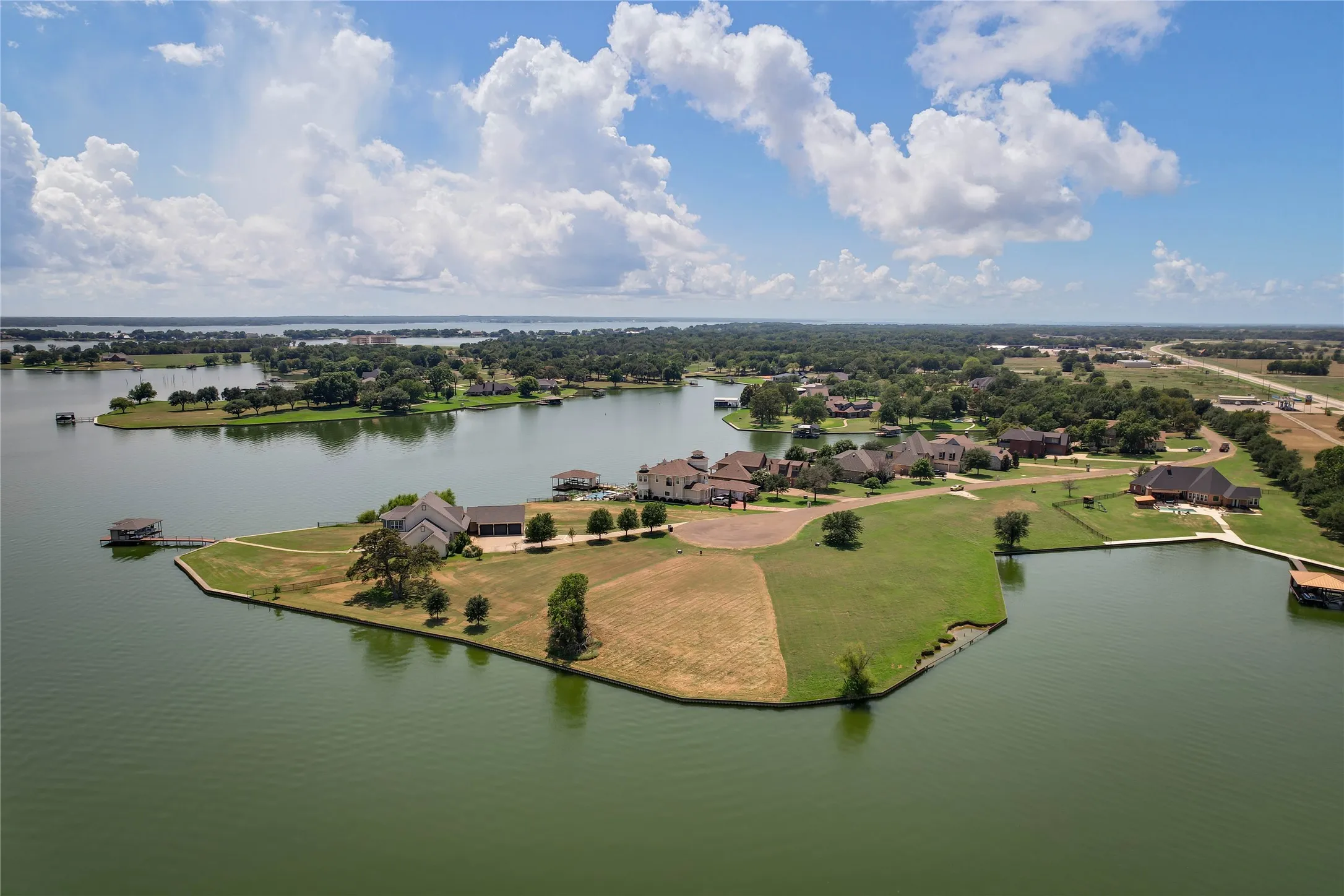 Aerial perspective of a waterfront peninsula featuring extensive shoreline, private boat dock, multi-acre parcel, and expansive water exposure