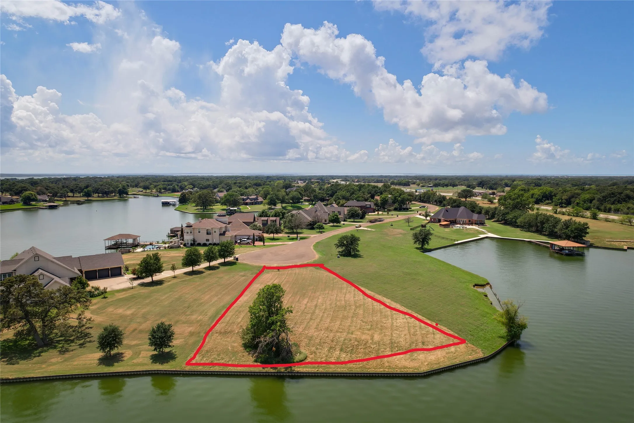 Waterfront lot featuring extensive lake frontage, bulkhead, and mature trees within a landscaped residential community