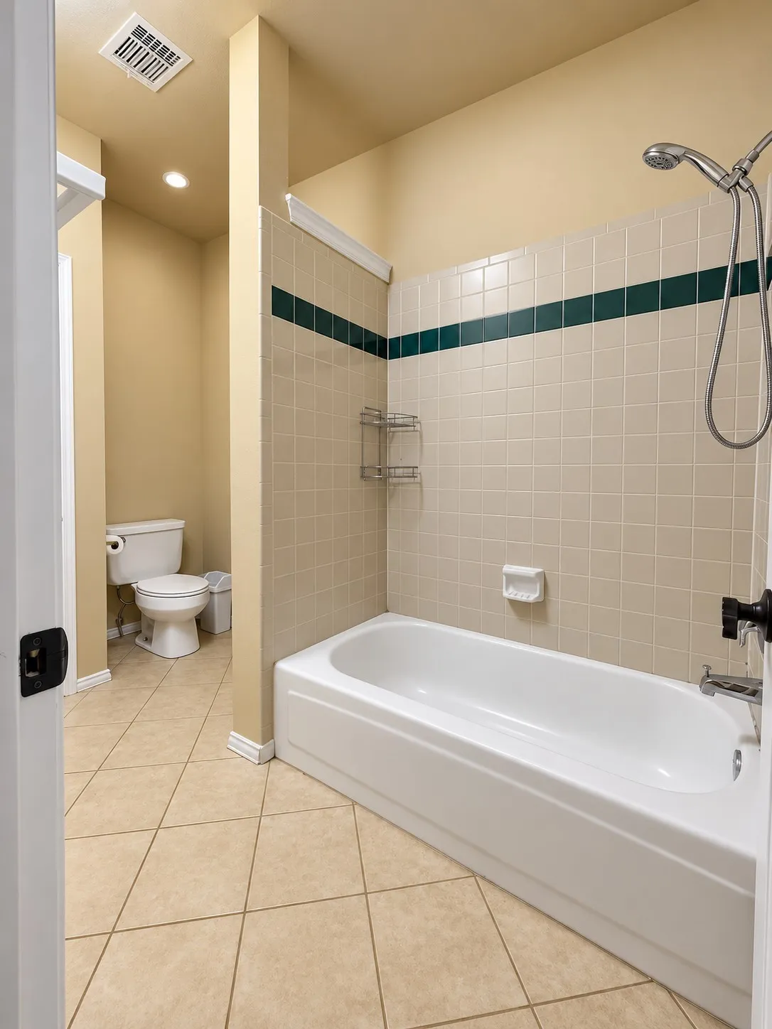 Tile flooring with a matching tiled shower surround, featuring a dark accent band