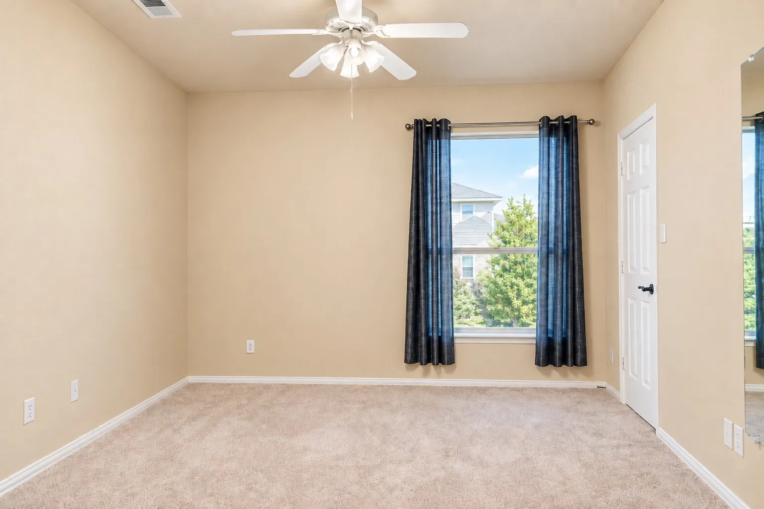 Neutral-toned walls complement plush carpeting