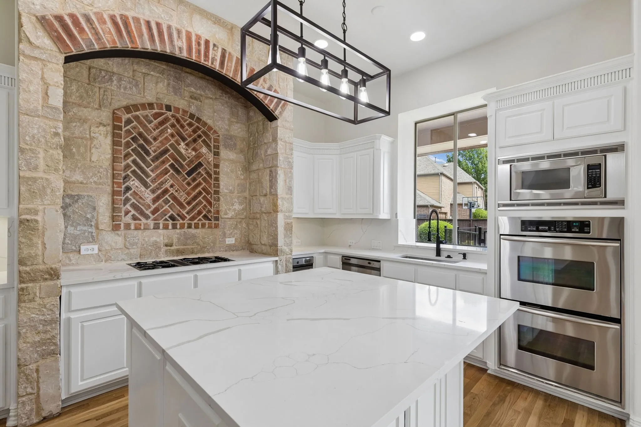 The kitchen has a gas cooktop and views of the backyard.