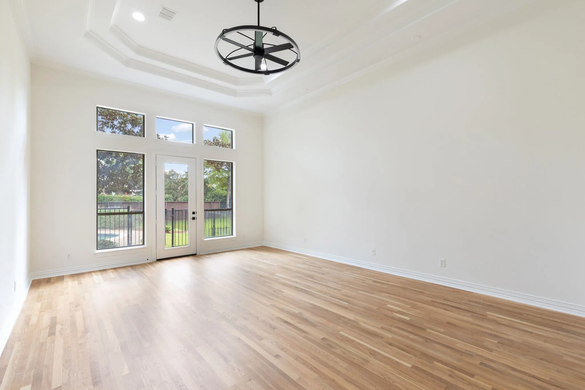 The oversized primary suite has wall of windows with views of the backyard.