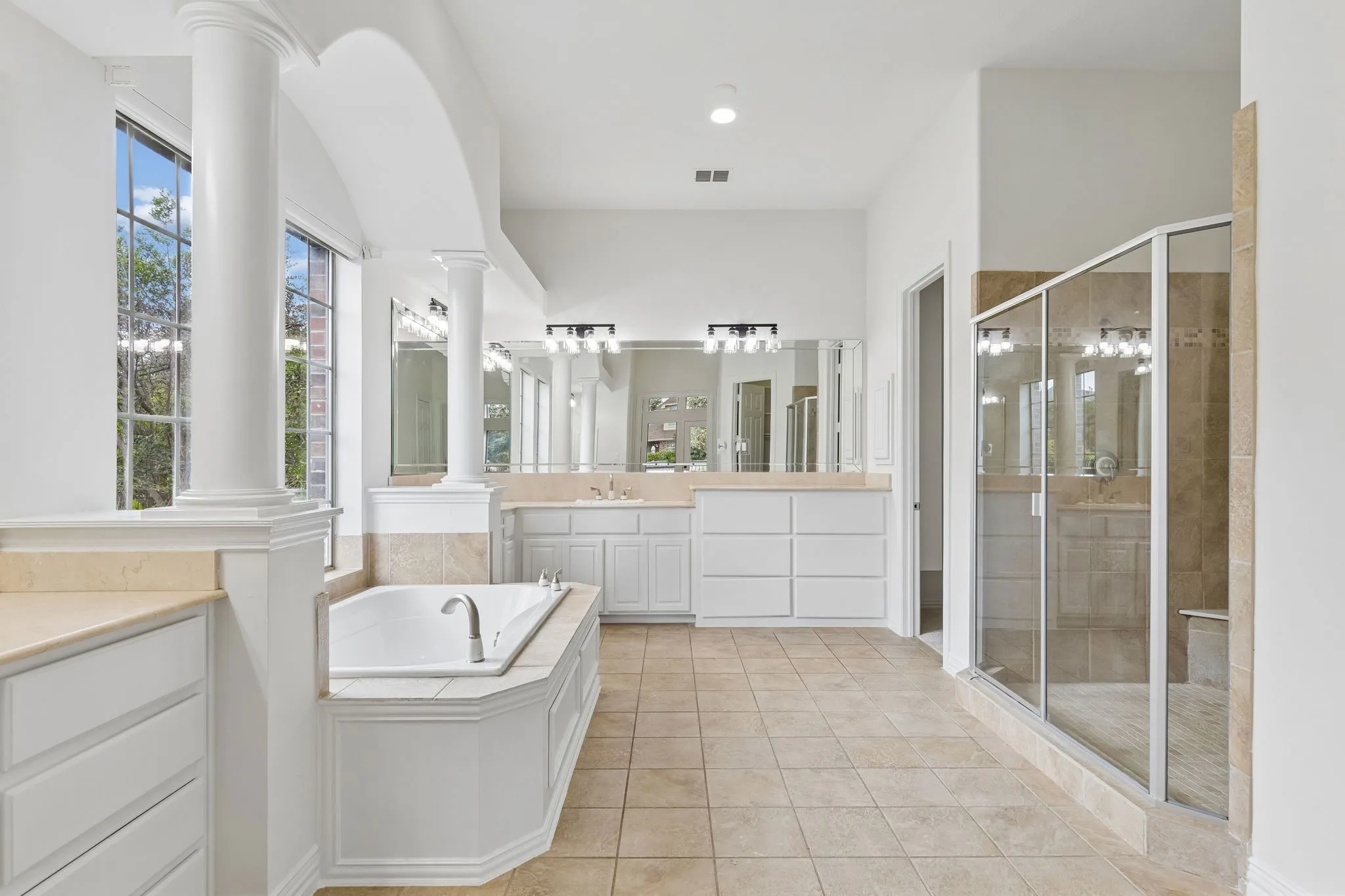 Ensuite bath complete with a dual shower, separate tub, separate vanities with extra storage.