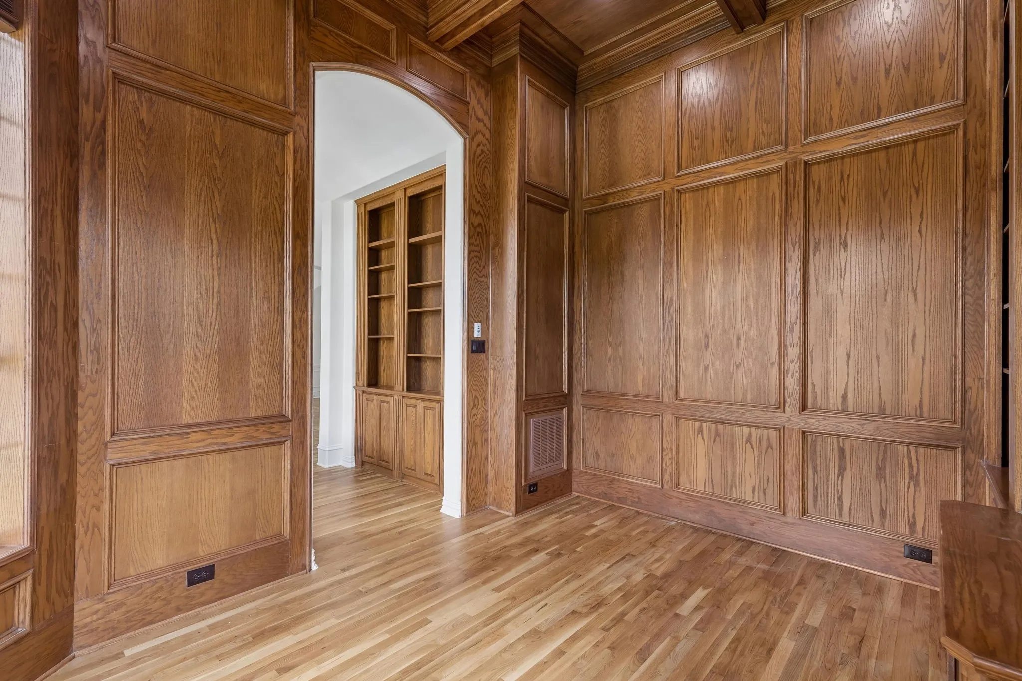 Office boasts floor to ceiling paneling, coffered ceiling and custom built-ins.