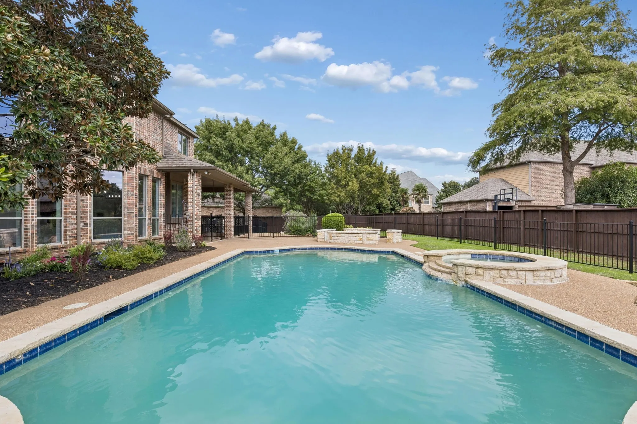 A sparkling pool and spa serve as the centerpiece for this restful outdoor space.