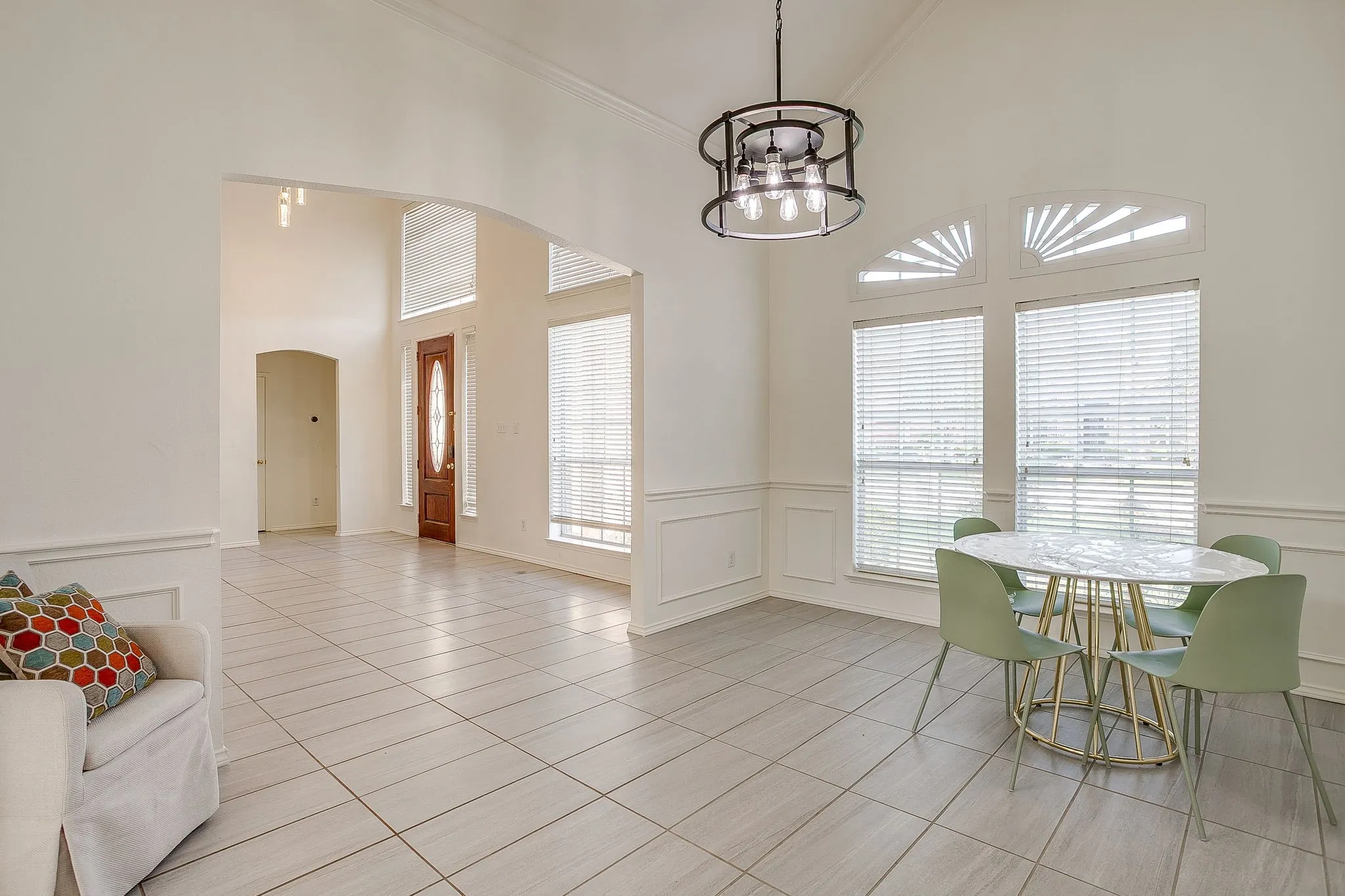 Vaulted ceilings, tile flooring, wainscoting, and decorative lighting