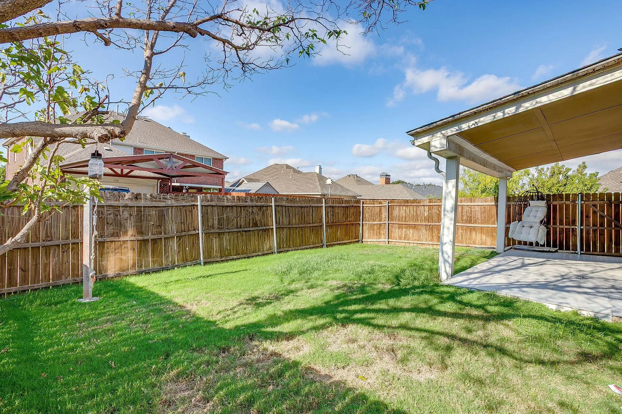 Backyard featuring a concrete patio, covered porch, wood privacy fencing