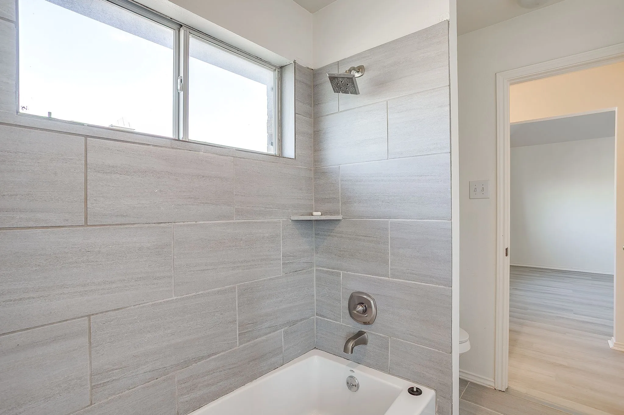Shared tiled tub and shower combinationin Jack and Jill bathroom.