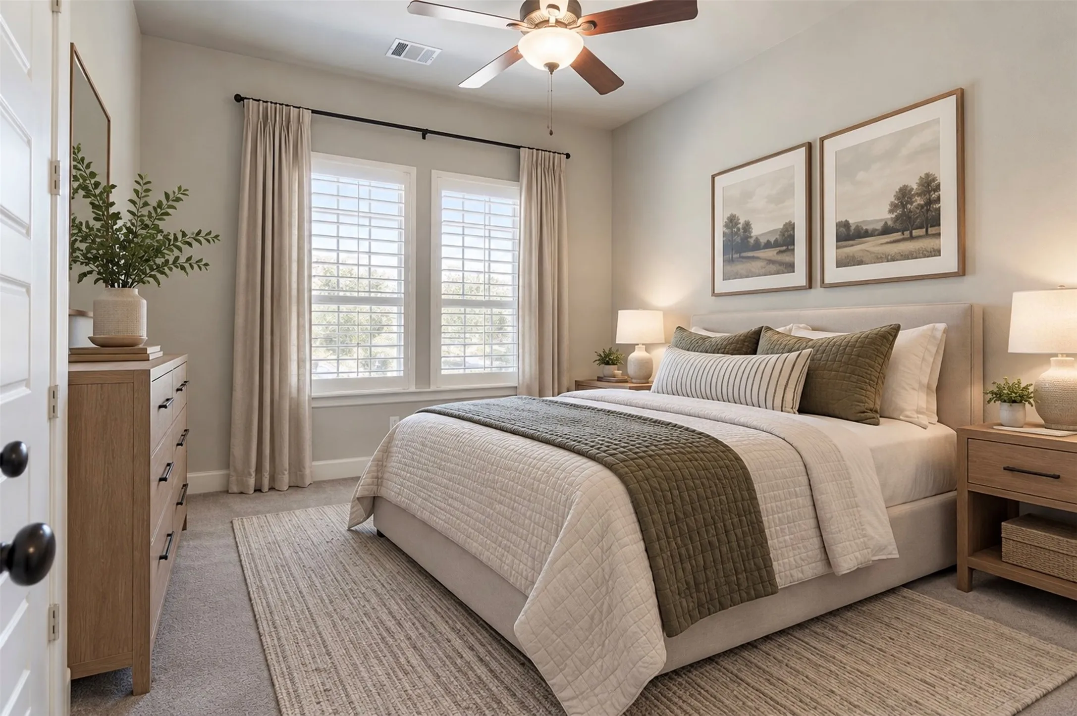 Neutral-toned interior space featuring window-mounted plantation shutters, wall-to-wall carpeting, and a central ceiling fan with integrated lighting