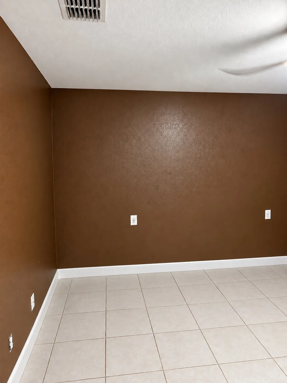 Neutral-toned ceramic tile flooring paired with solid-colored wall finishes