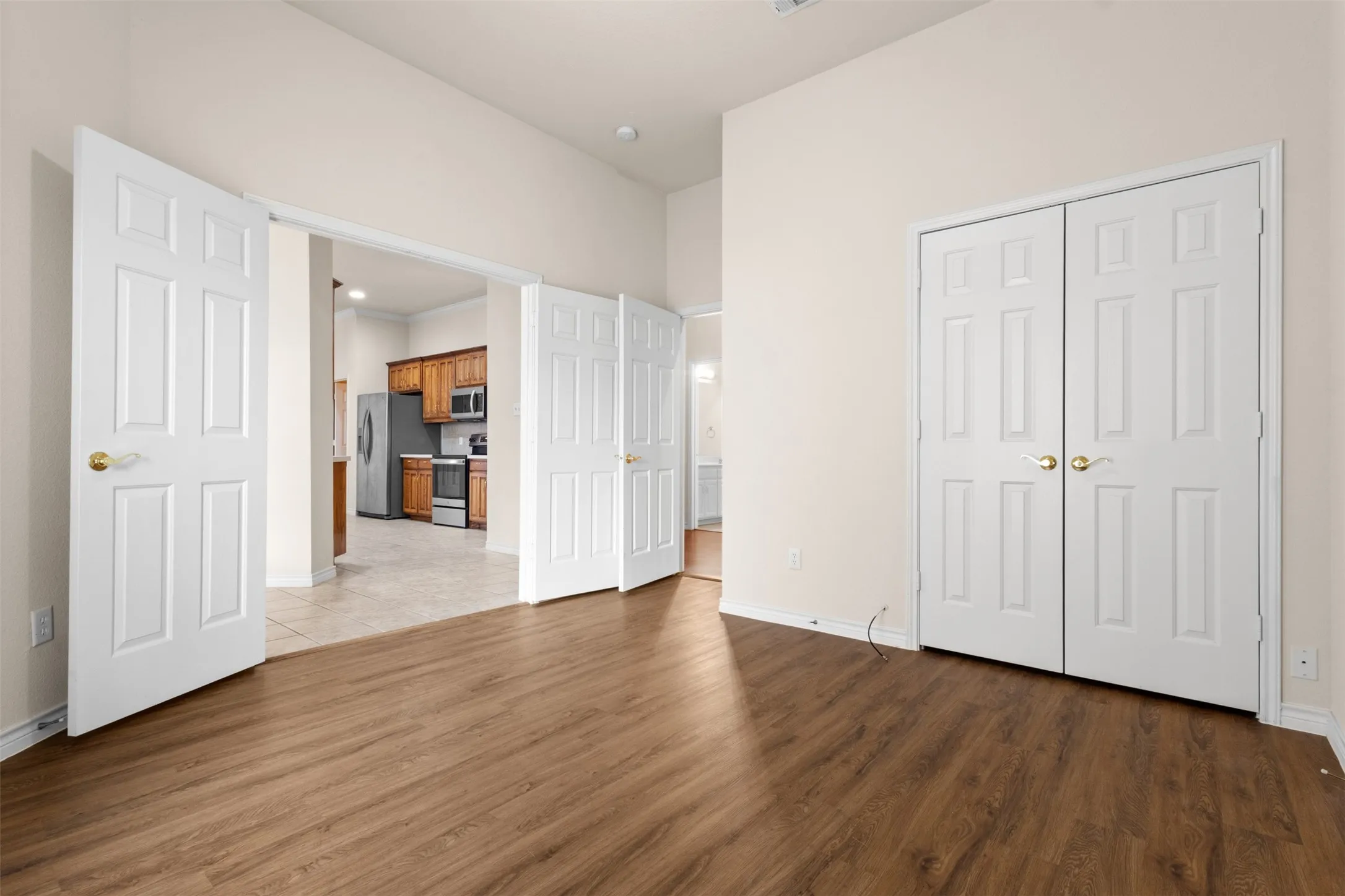 Interior room featuring wood-finish flooring, double-panel interior doors, and high ceilings