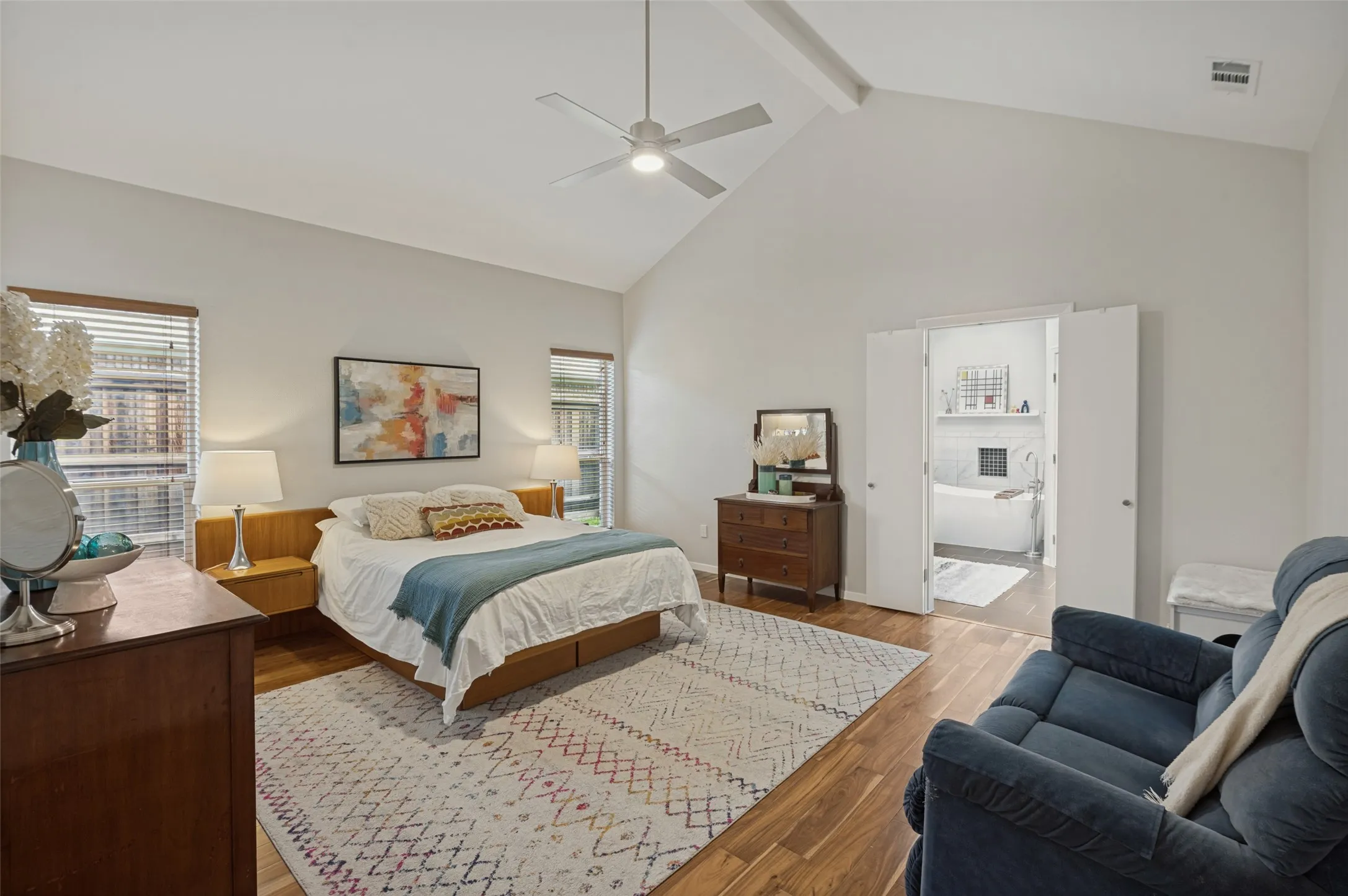 Spacious primary bedroom with sitting area and vaulted ceilings