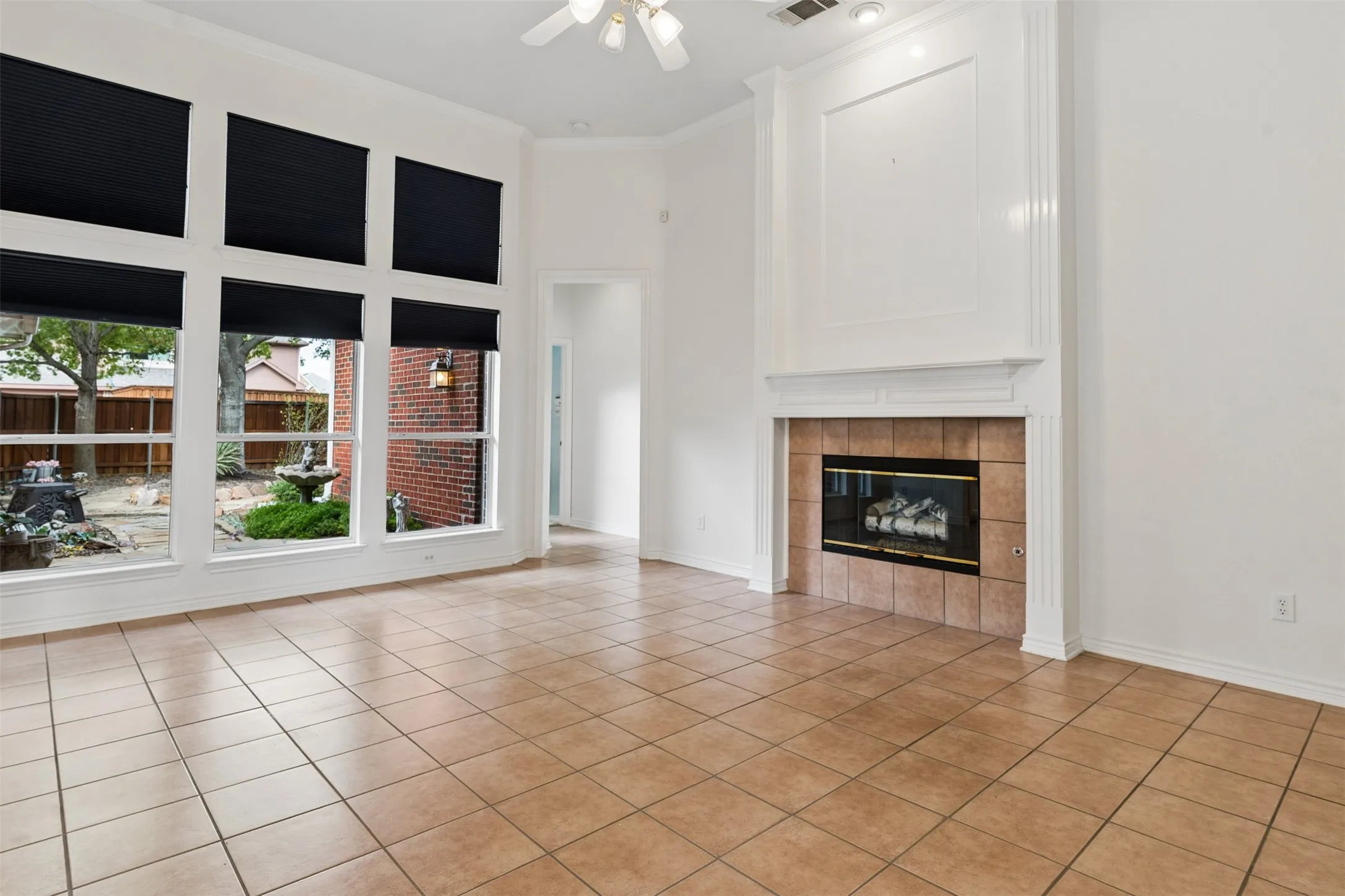 Living area featuring tile flooring, a fireplace with a ceramic tile surround and mantel, and expansive windows