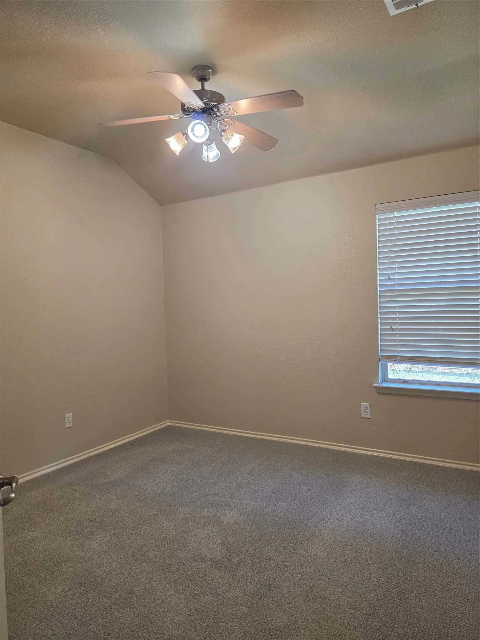 Vaulted ceiling featuring a ceiling fan with integrated lighting and neutral carpeting​​‌​​​​‌​​‌‌​‌‌​​​‌‌​‌​‌​‌​​​‌​​ throughout