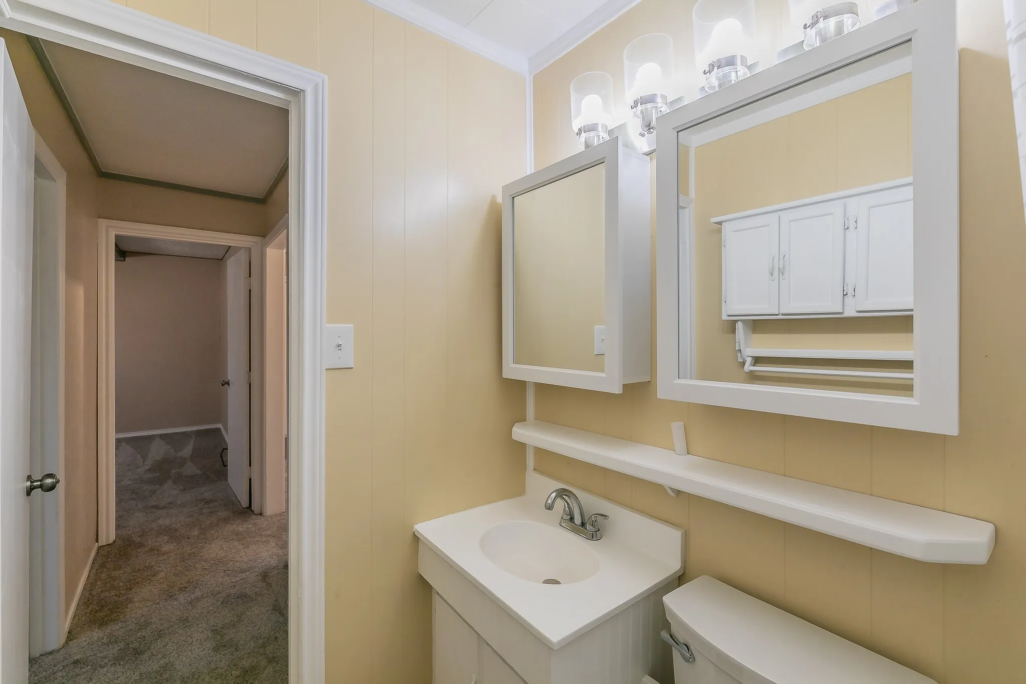 Bathroom featuring toilet, ornamental molding, and sink
